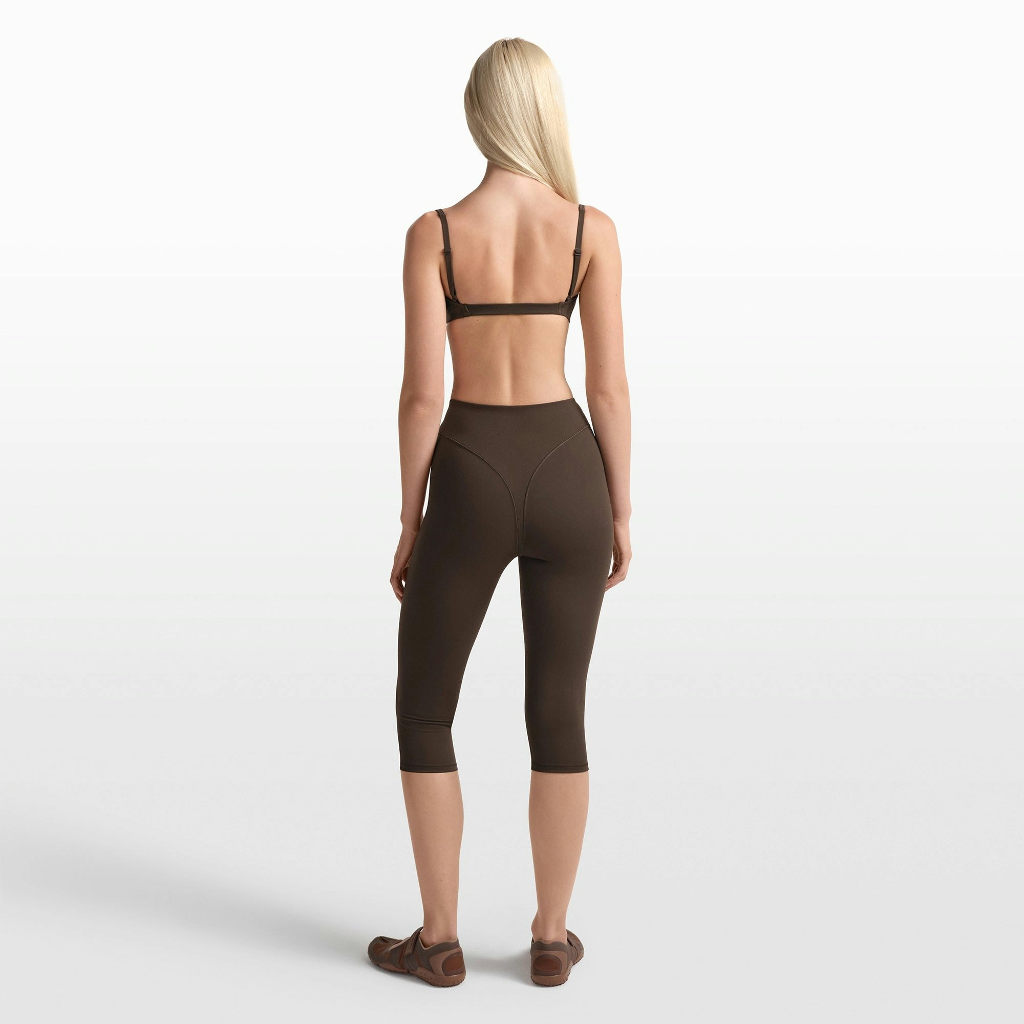 NikeSKIMS MATTE 17" V-LINE CROP LEGGING | DARK SEPIA ON A MODEL FRONT VIEW @ | FOCUS: 0.0, 1.0, 0.9