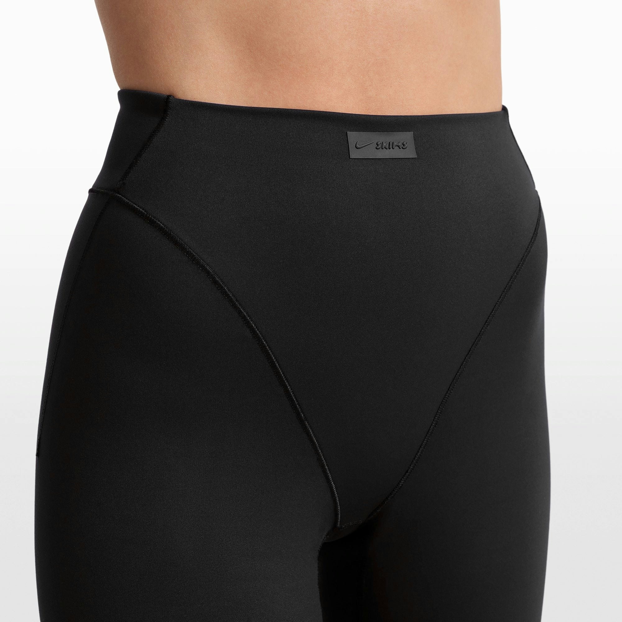 NikeSKIMS MATTE 17" V-LINE CROP LEGGING | OBSIDIAN ON A MODEL FRONT VIEW @ | FOCUS: 0.0, 1.0, 0.9