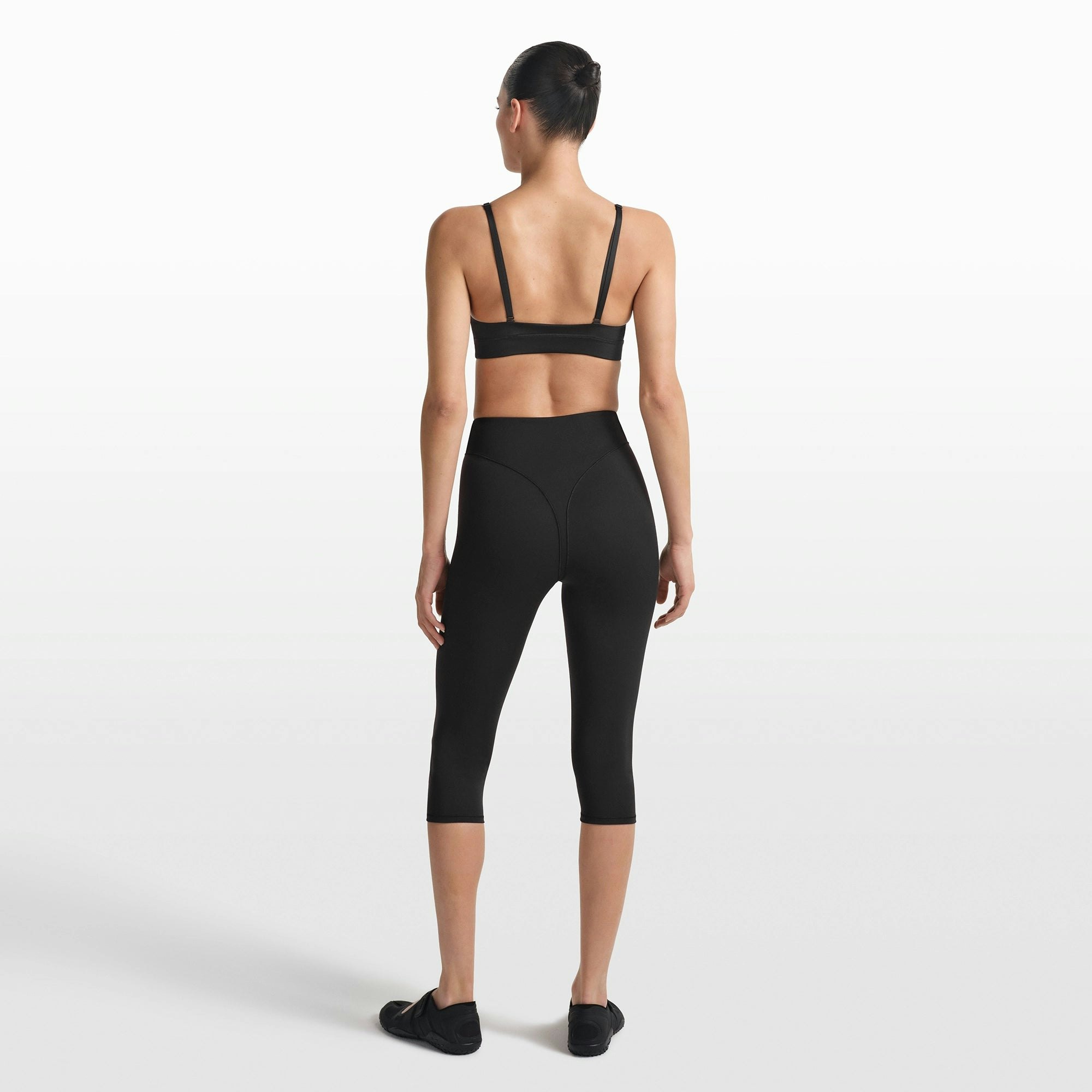 NikeSKIMS MATTE 17" V-LINE CROP LEGGING | OBSIDIAN ON A MODEL FRONT VIEW @ | FOCUS: 0.0, 1.0, 0.9