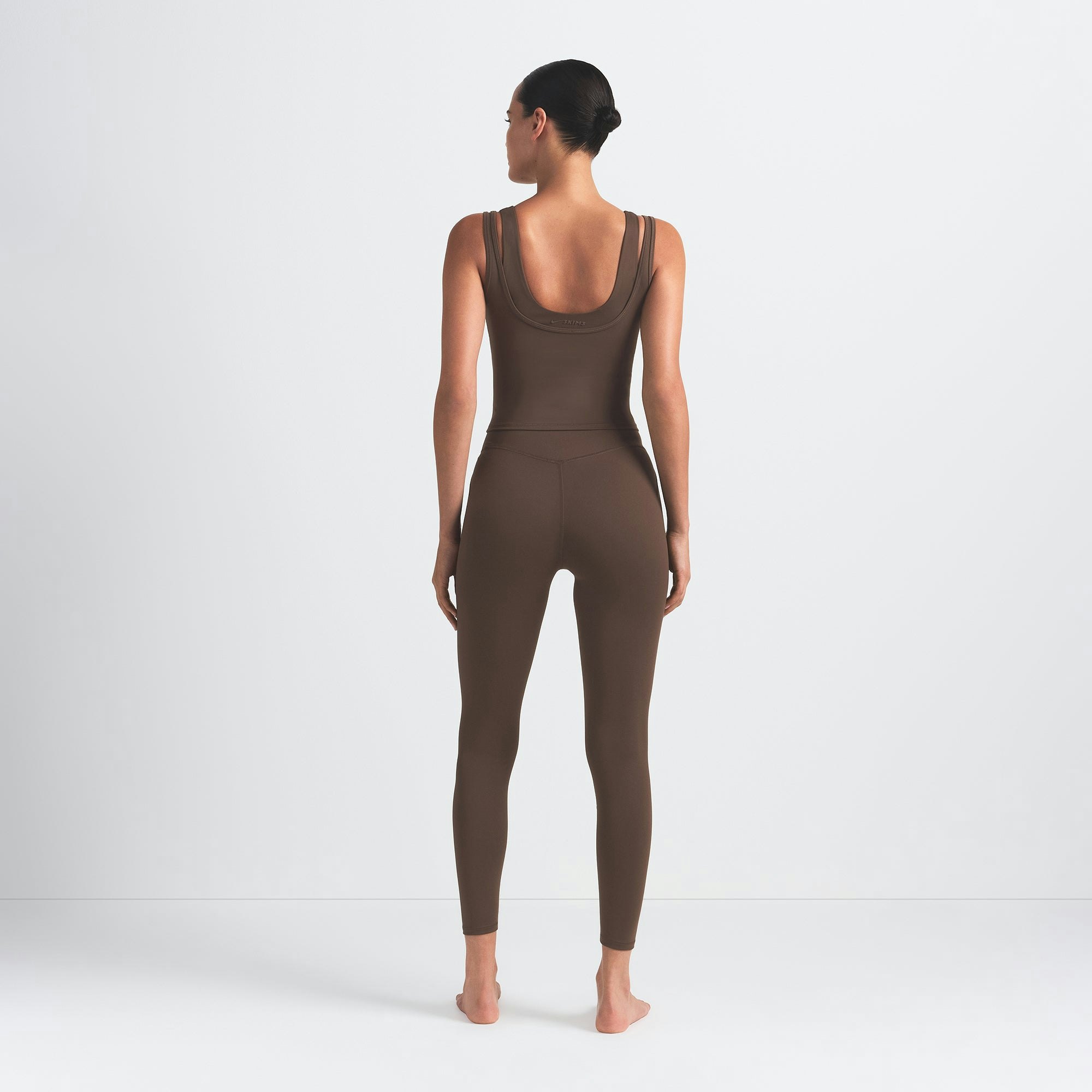 NikeSKIMS MATTE KNEE GRIP 26" LEGGING | DARK SEPIA ON A MODEL BACK VIEW @ | FOCUS: 0.0, 1.0, 0.9