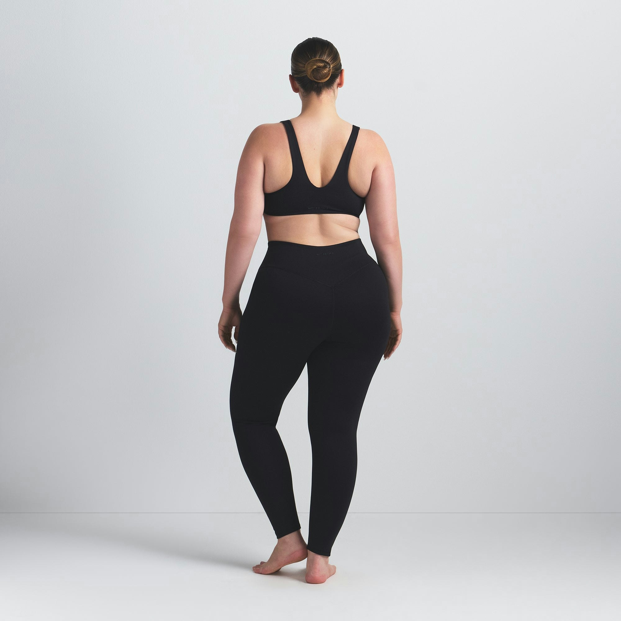 NikeSKIMS MATTE KNEE GRIP 26" LEGGING | OBSIDIAN ON A MODEL BACK VIEW @ | FOCUS: 0.0, 1.0, 0.9