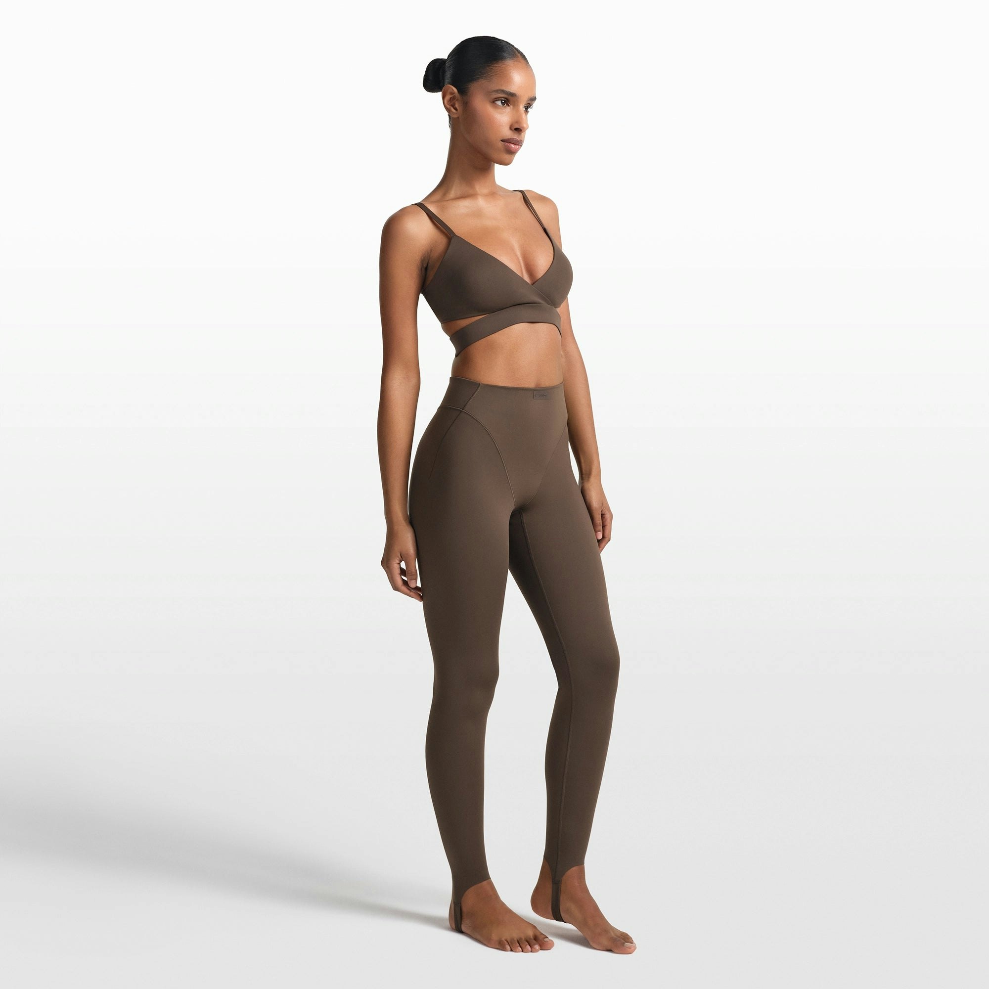 NikeSKIMS MATTE V-LINE STIRRUP LEGGING | DARK SEPIA ON A MODEL FRONT VIEW @ | FOCUS: 0.0, 1.0, 0.9