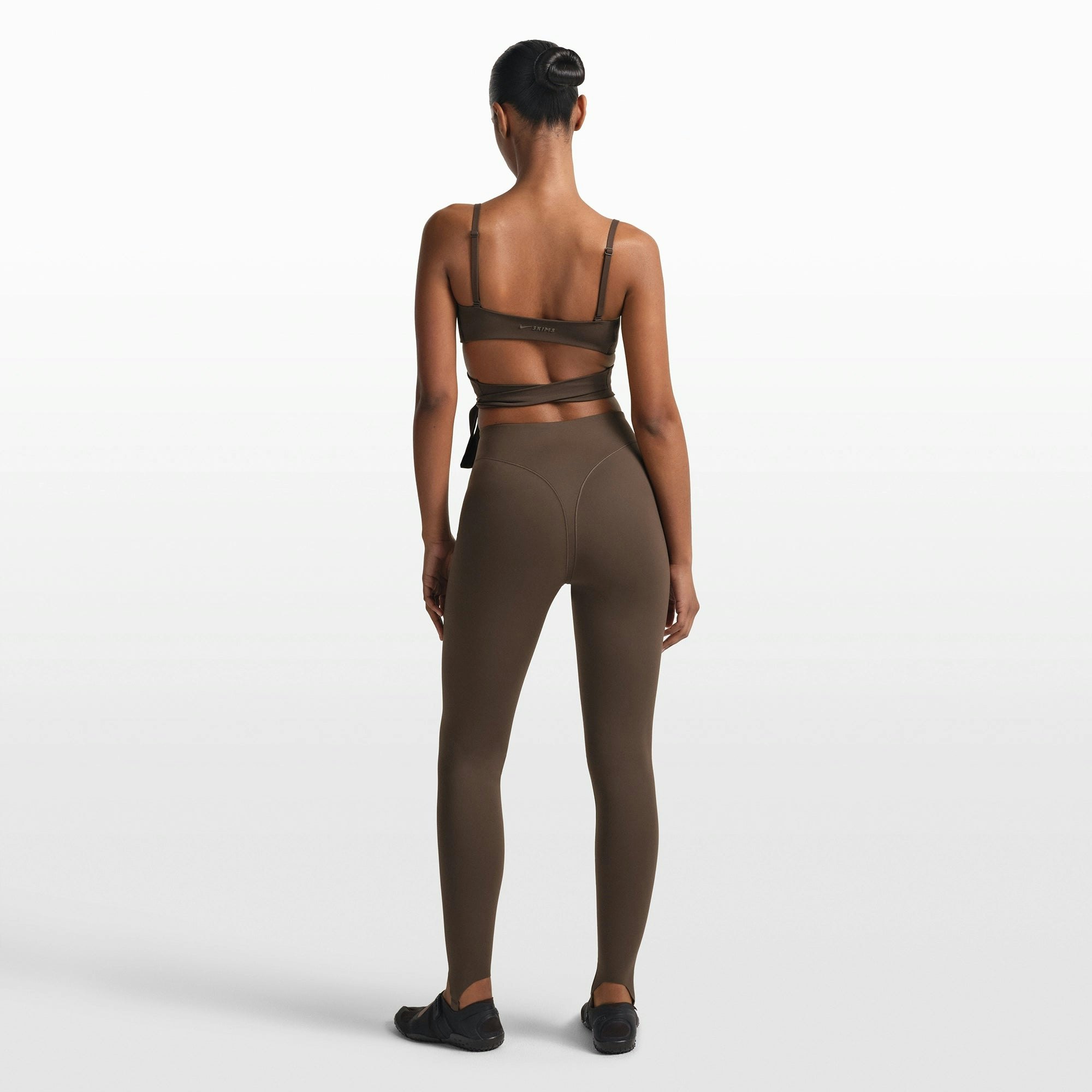 NikeSKIMS MATTE V-LINE STIRRUP LEGGING | DARK SEPIA ON A MODEL FRONT VIEW @ | FOCUS: 0.0, 1.0, 0.9