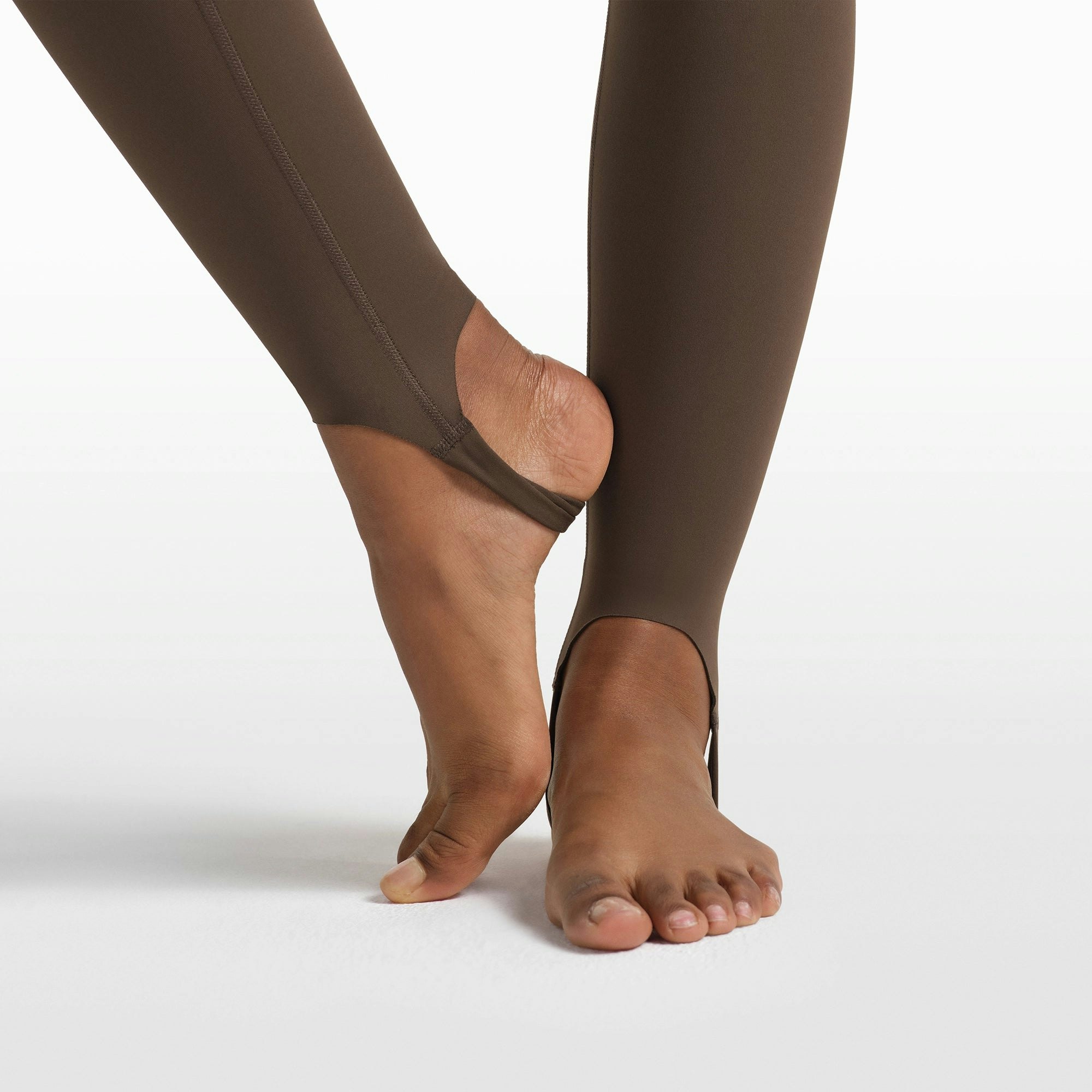 NikeSKIMS MATTE V-LINE STIRRUP LEGGING | DARK SEPIA ON A MODEL FRONT VIEW @ | FOCUS: 0.0, 1.0, 0.9