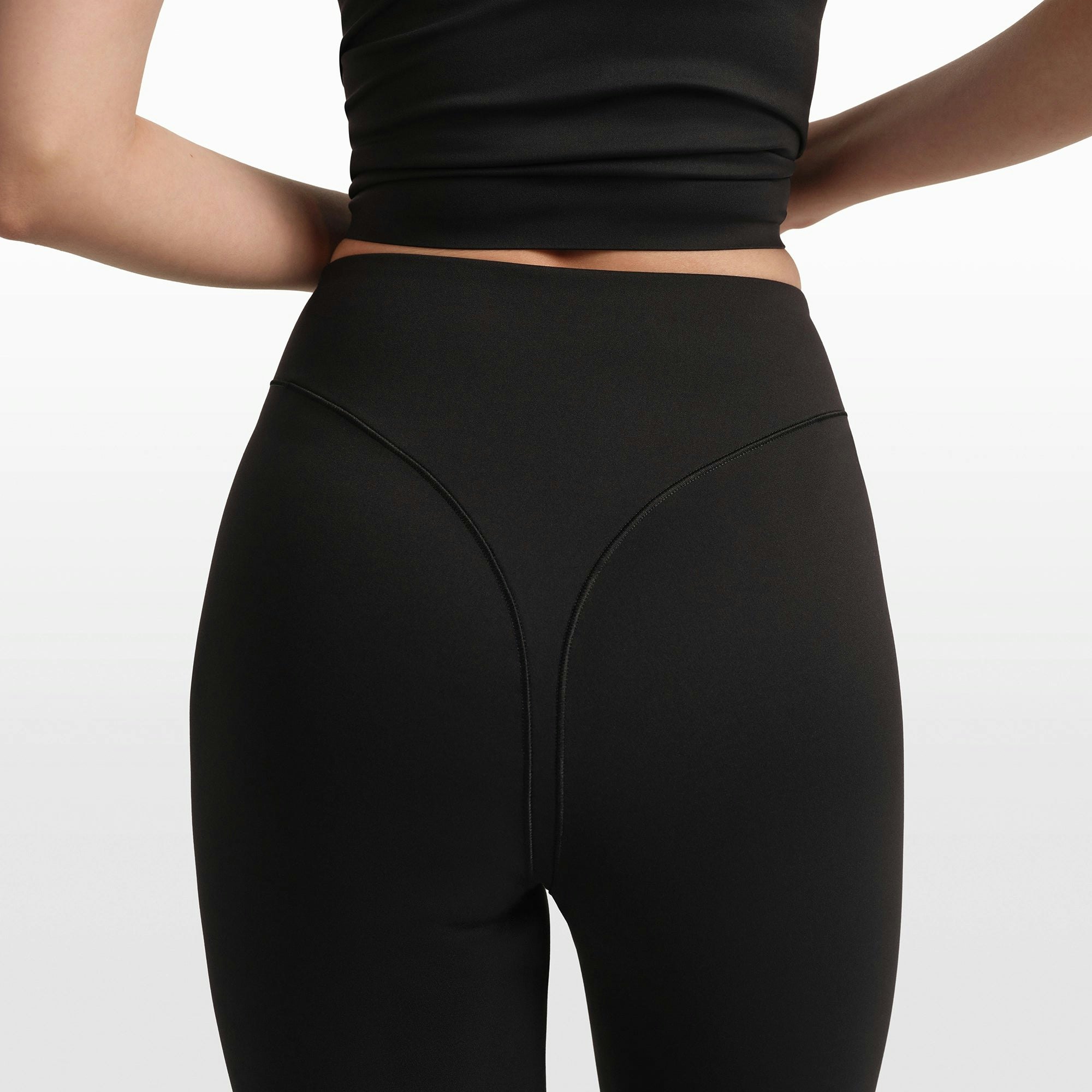 NikeSKIMS MATTE V-LINE STIRRUP LEGGING | OBSIDIAN ON A MODEL FRONT VIEW @ | FOCUS: 0.0, 1.0, 0.9