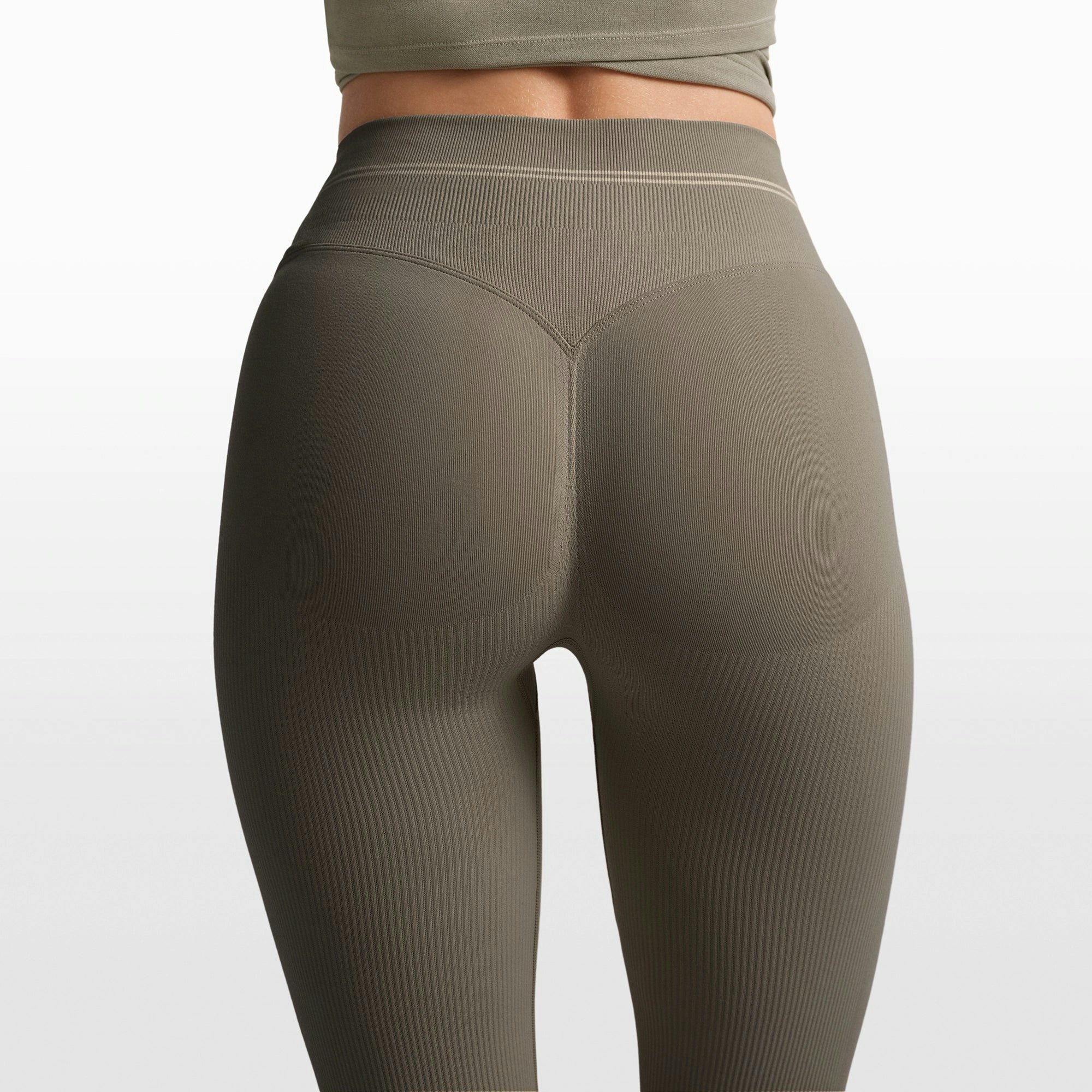 NikeSKIMS RIBBED SEAMLESS 34" STRAIGHT LEGGING | DUSTY OAKMOSS/DUNE ON A MODEL FRONT VIEW @ | FOCUS: 0.0, 1.0, 0.9