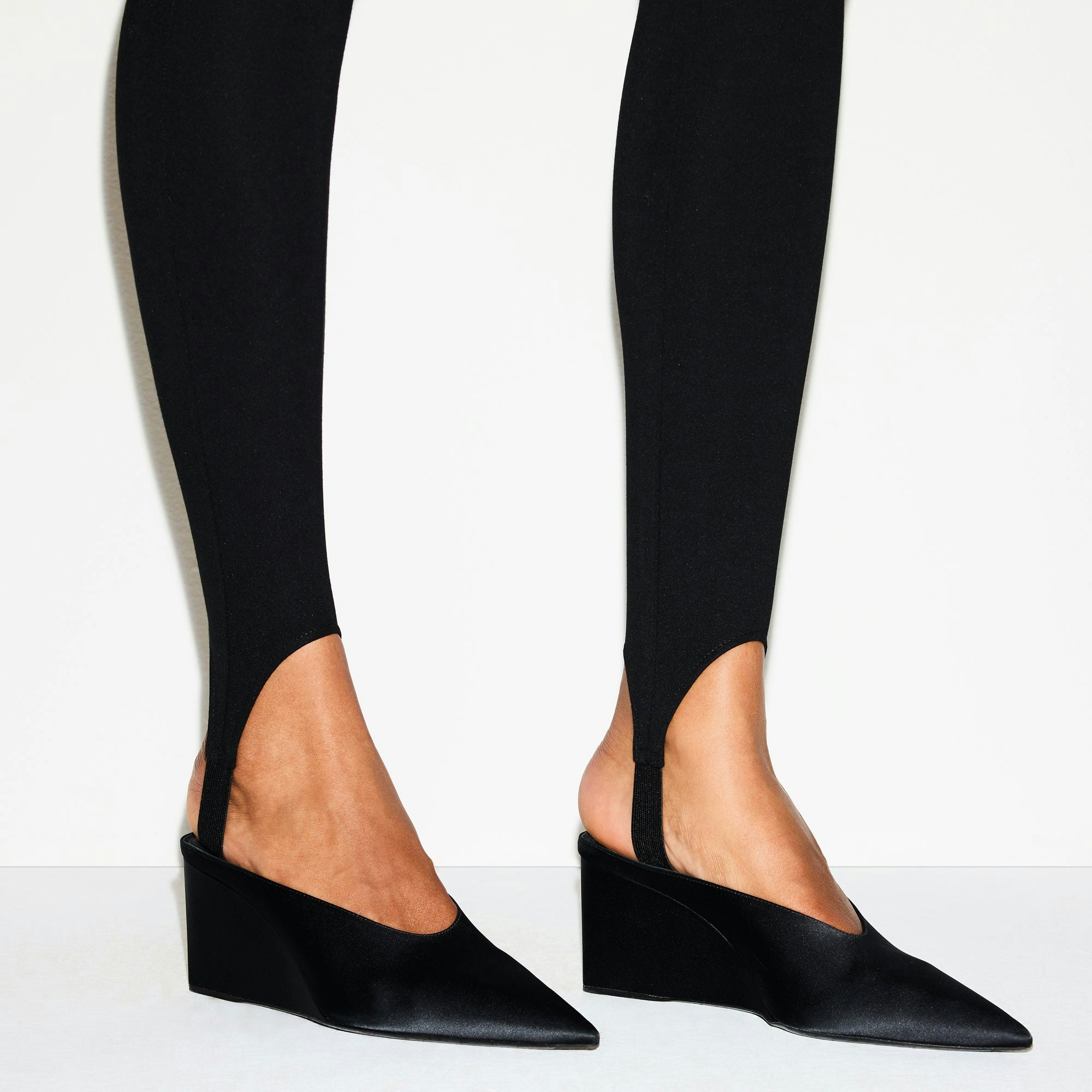 THE ESSENTIAL COLLECTION HIGH-WAISTED STIRRUP LEGGING | OBSIDIAN ON A MODEL SIDE VIEW @ | FOCUS: 0.0, 1.0, 0.9