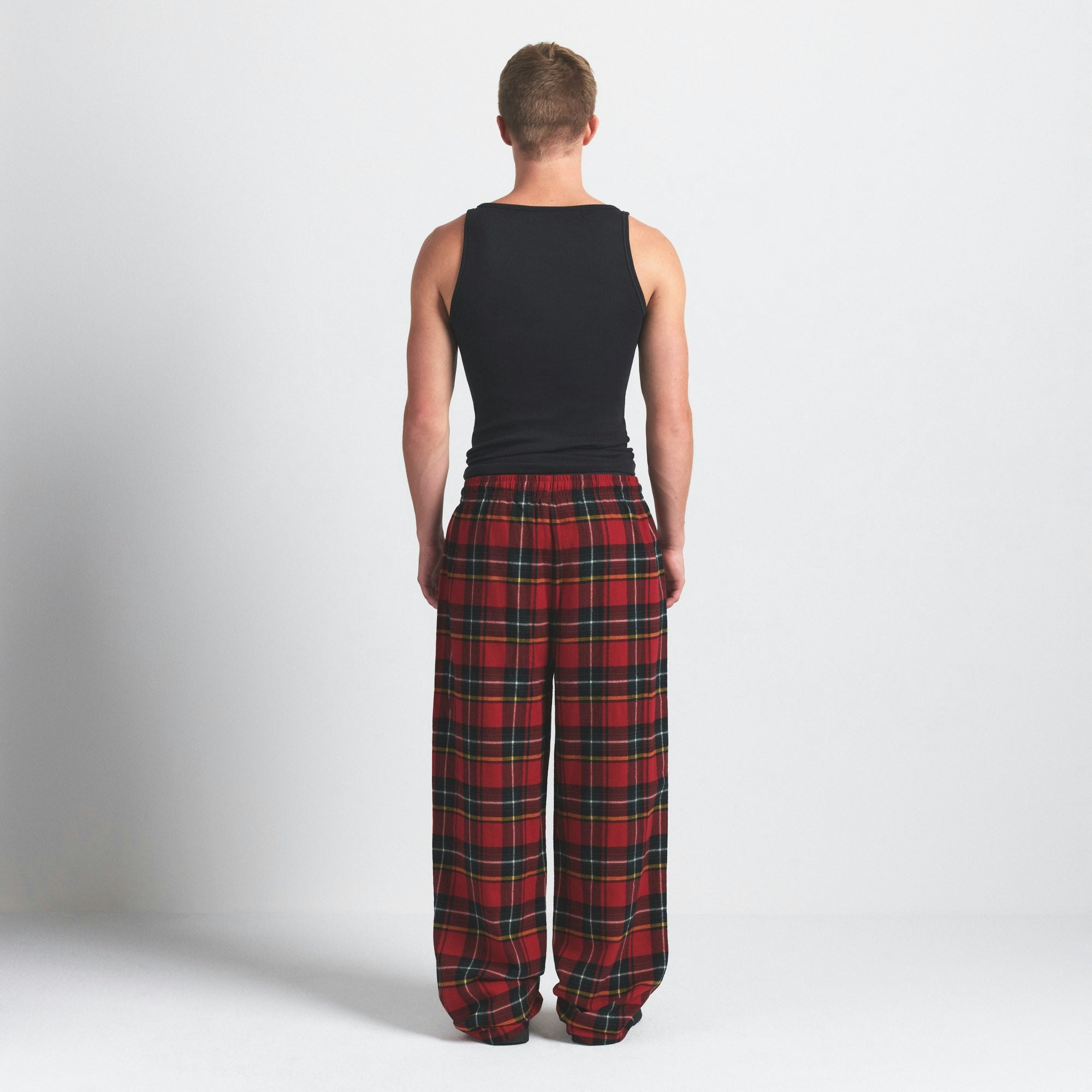 FLANNEL SLEEP MENS PANT | RED HOLIDAY PLAID ON A MODEL SIDE VIEW @ | FOCUS: 0.0, 1.0, 0.9