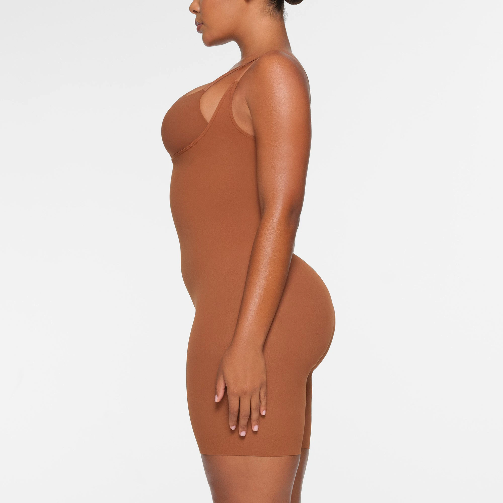 BUTT ENHANCING OPEN BUST BODYSUIT WORN BY A MODEL IN SIDE VIEW