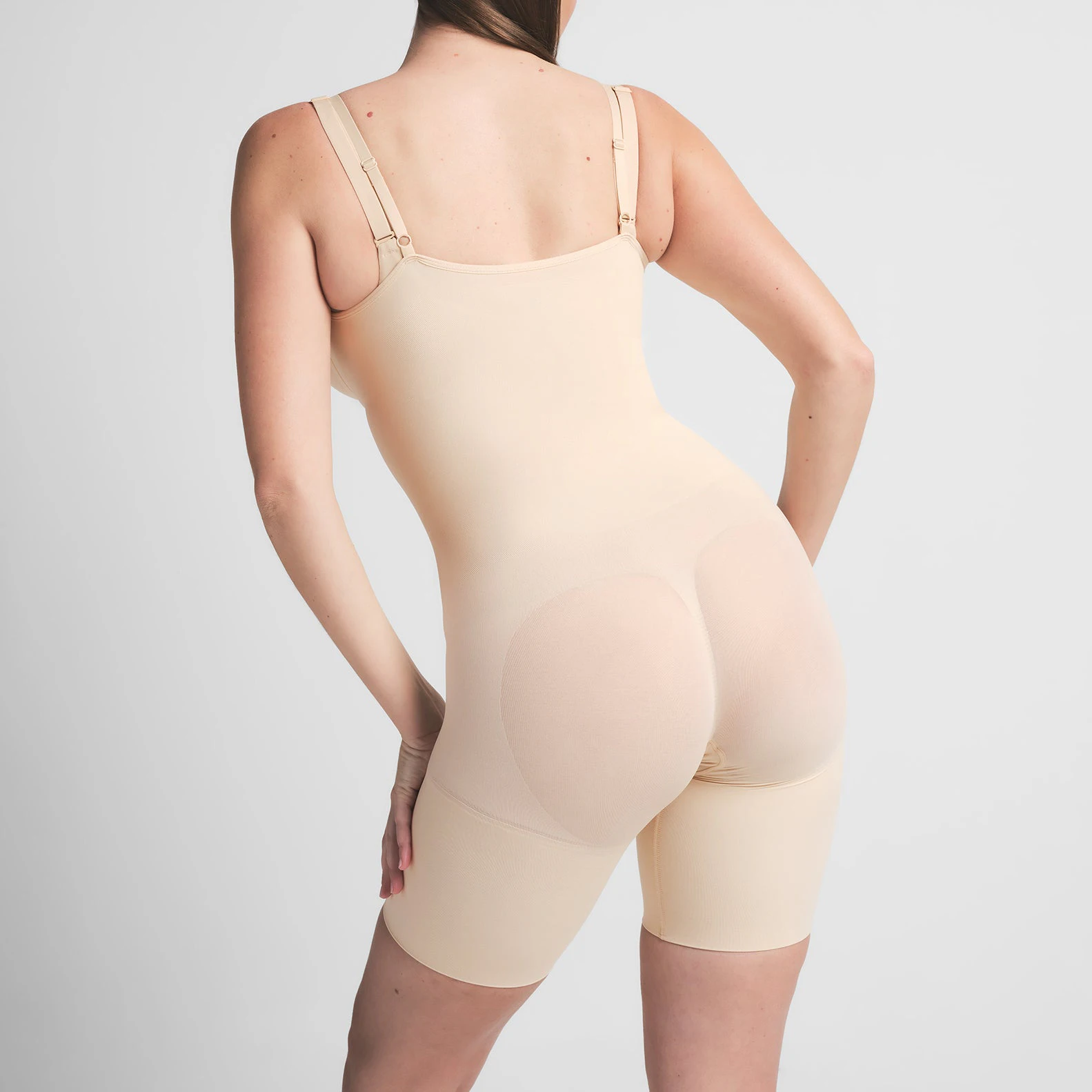 SEAMLESS SCULPT BUTT LIFTING OPEN BUST BODYSUIT | SAND ON A MODEL BACK VIEW