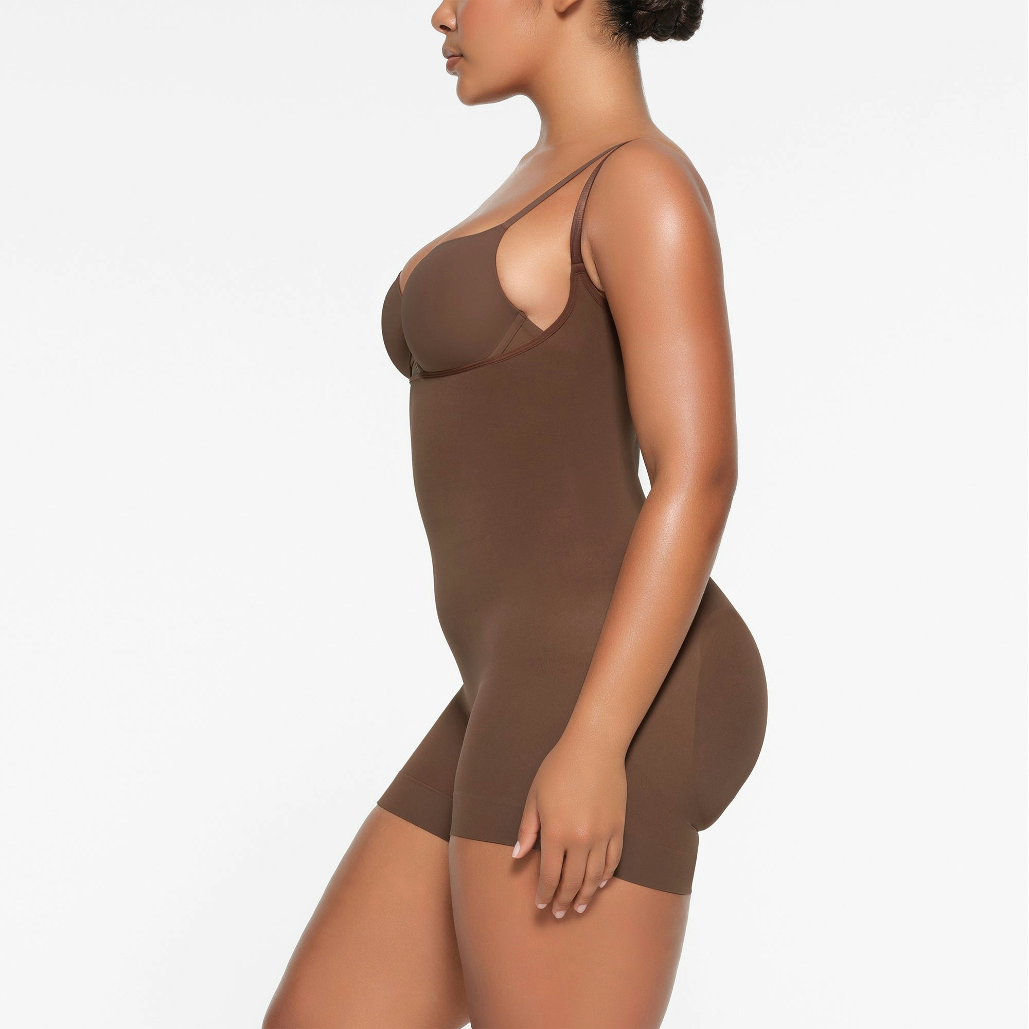 SEAMLESS SCULPT OPEN BUST SHORTIE BODYSUIT WORN BY A MODEL IN SIDE VIEW