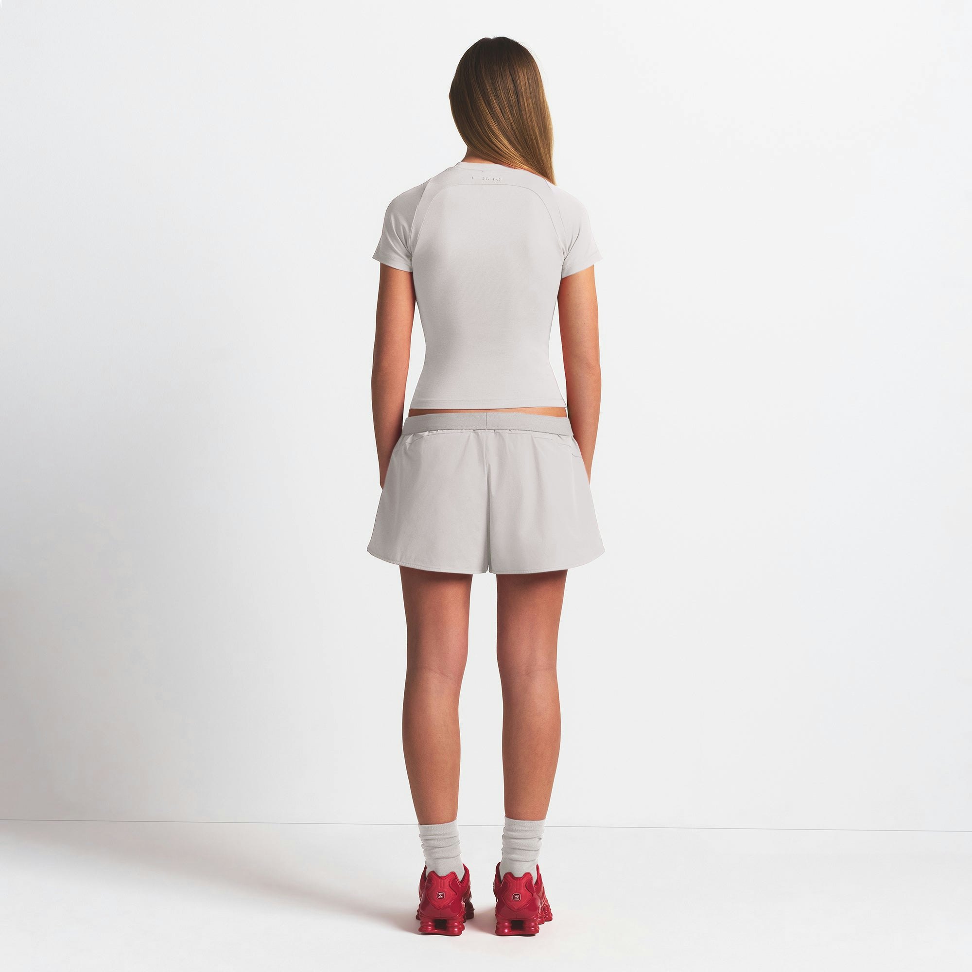 NikeSKIMS WOVEN NYLON 2.5" RUNNER SHORT | STONE ON A MODEL BACK VIEW @ | FOCUS: 0.9, 0.1, 0.7