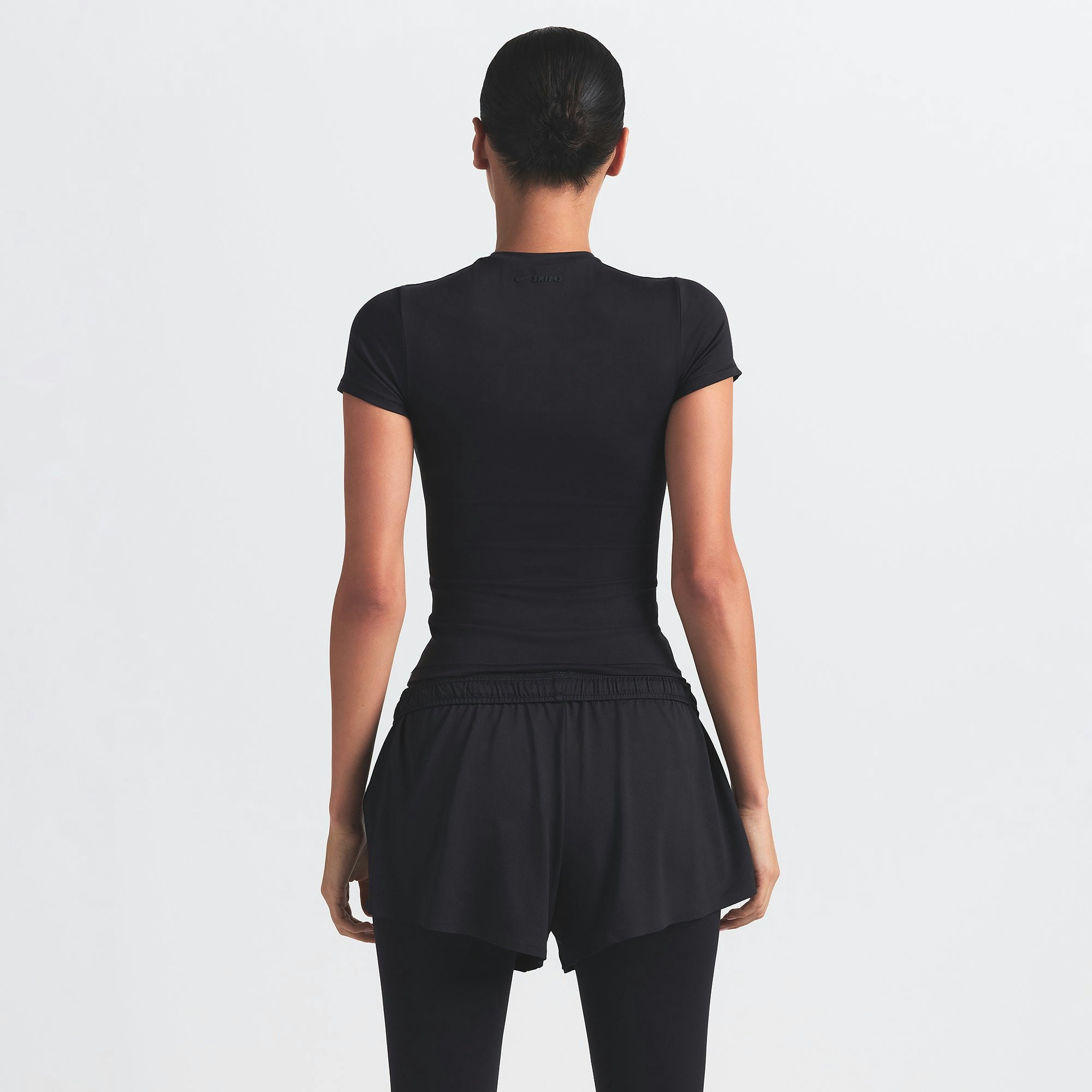 NikeSKIMS AIRY MINI SHORT | OBSIDIAN ON A MODEL BACK VIEW @ | FOCUS: 0.9, 0.1, 0.7