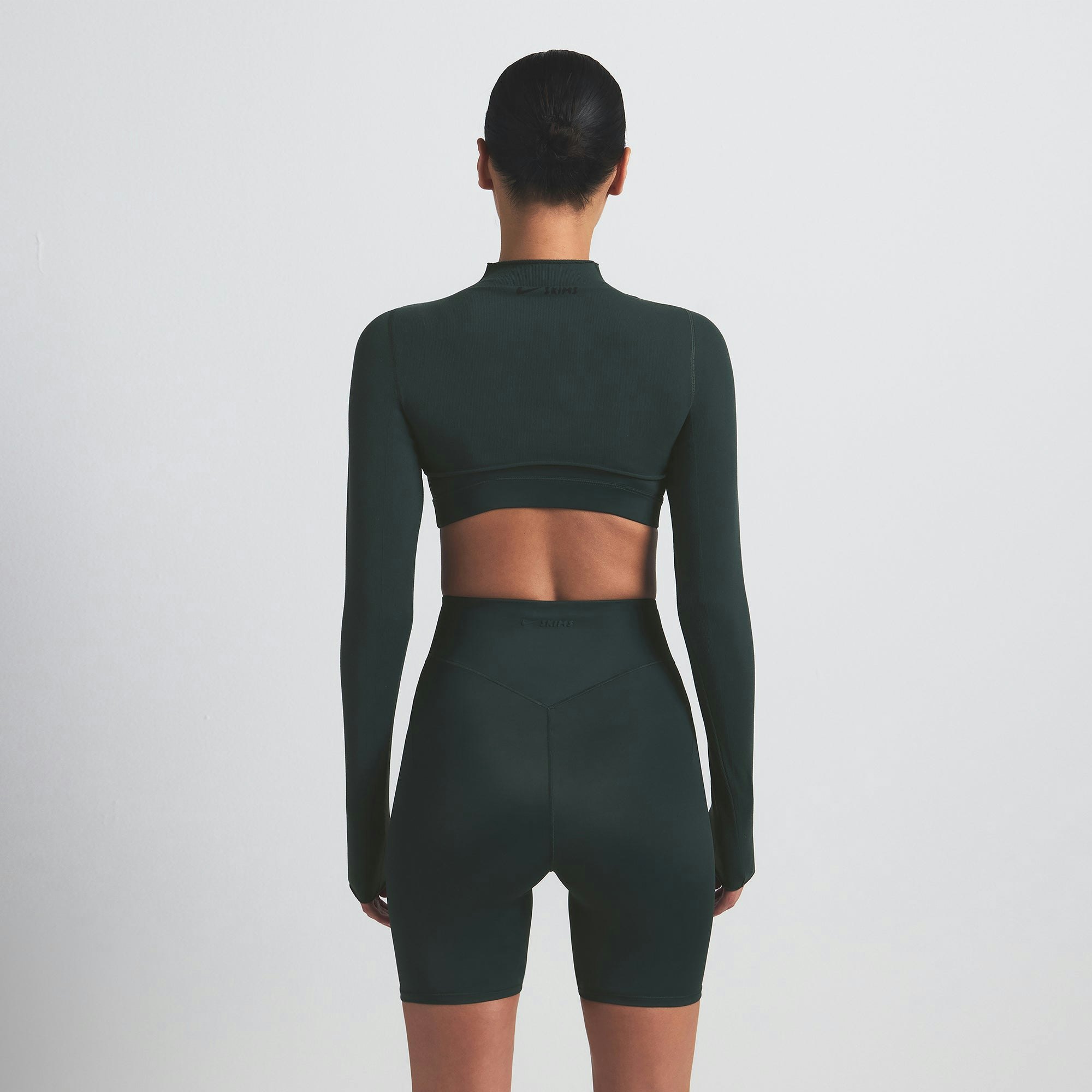 NikeSKIMS SHINE BONDED WAIST 5" BIKER SHORT | DARK TEAL ON A MODEL SIDE VIEW @ | FOCUS: 0.0, 1.0, 0.9