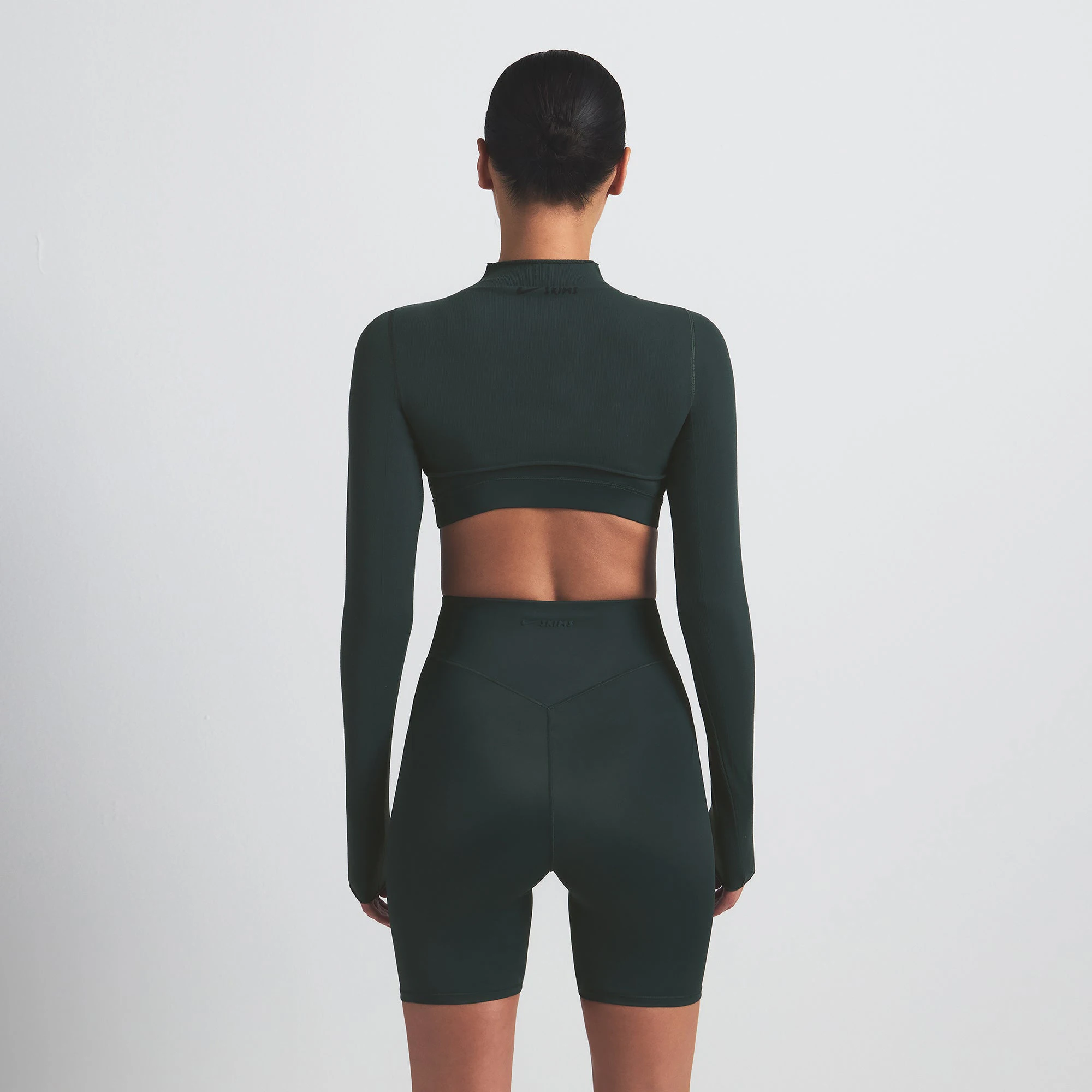 NikeSKIMS SHINE BONDED WAIST 5" BIKER SHORT | DARK TEAL ON A MODEL SIDE VIEW @ | FOCUS: 0.0, 1.0, 0.9