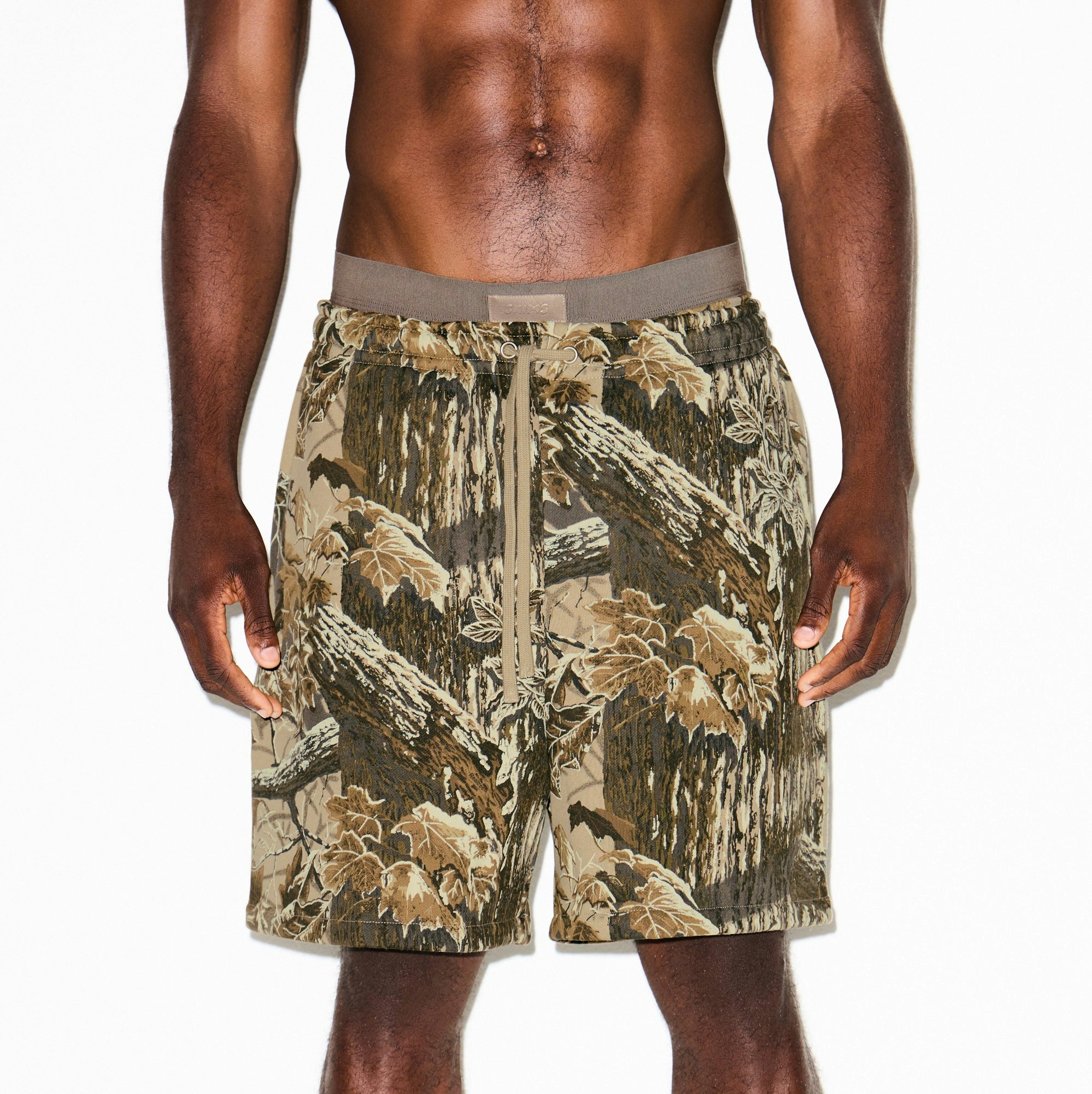 HEAVYWEIGHT FLEECE MENS RELAXED SHORT | REALTREE CAMO PRINT ON A MODEL SIDE VIEW @ | FOCUS: 0.9, 0.1, 0.7