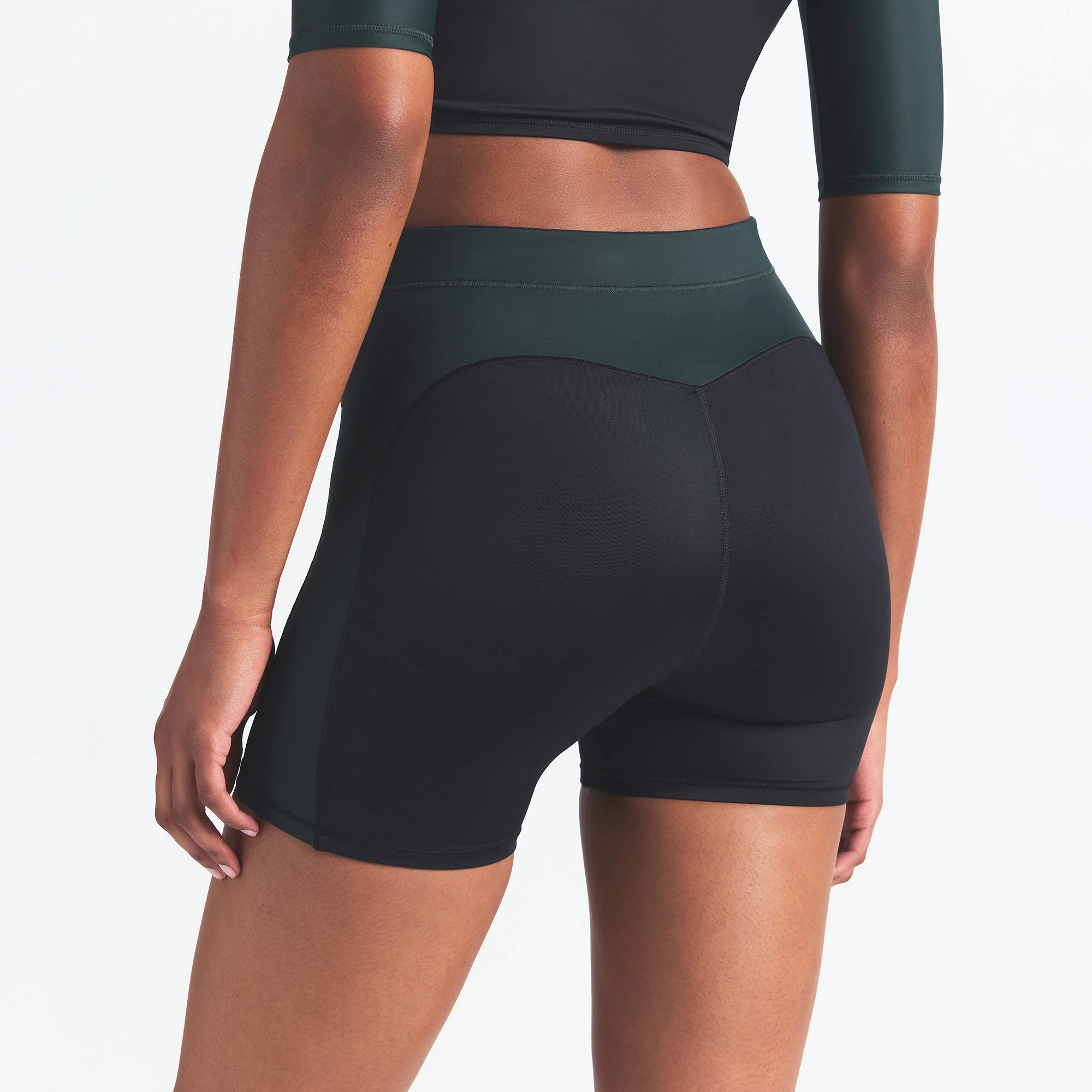 NikeSKIMS SHINE 5" BIKER SHORT | OBSIDIAN AND DARK TEAL ON A MODEL BACK VIEW @ | FOCUS: 0.0, 1.0, 0.9