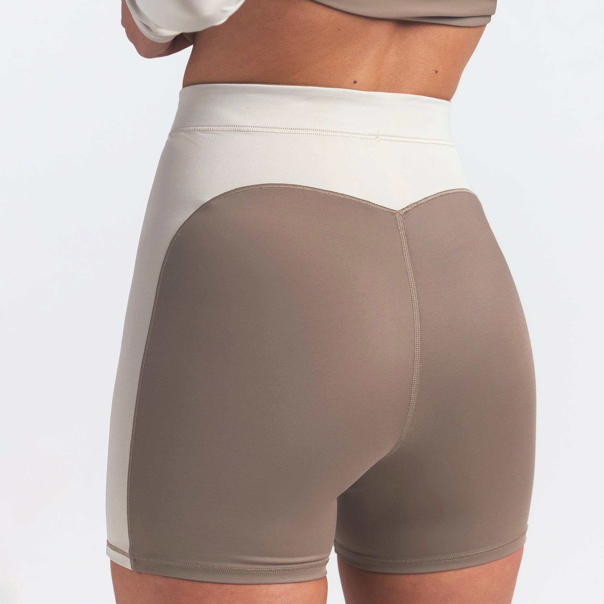 NikeSKIMS SHINE 5" BIKER SHORT | TRUFFLE AND STONE ON A MODEL BACK VIEW @ | FOCUS: 0.0, 1.0, 0.9