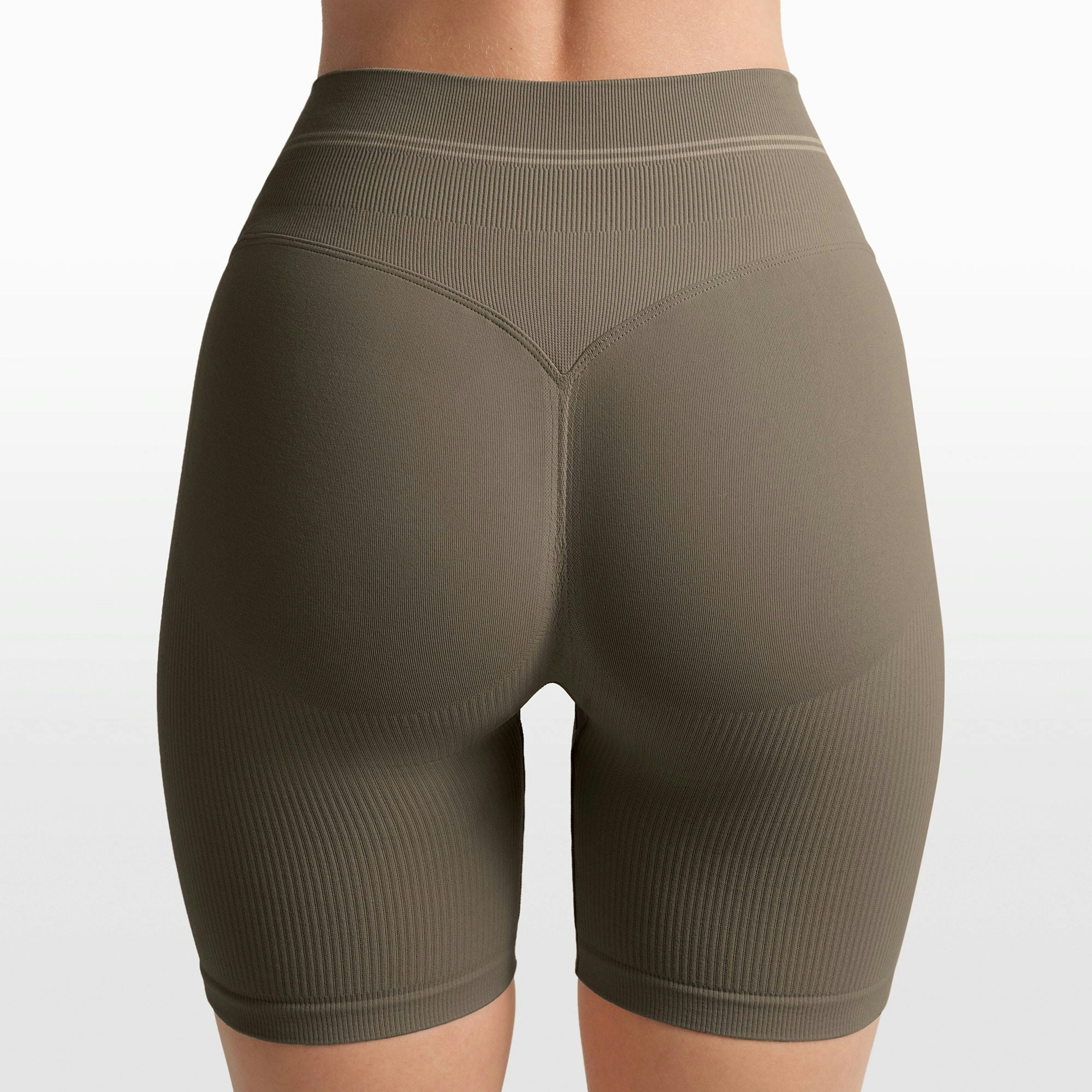 NikeSKIMS RIBBED SEAMLESS 5" BIKER SHORT | DUSTY OAKMOSS/DUNE ON A MODEL FRONT VIEW @ | FOCUS: 0.0, 1.0, 0.9