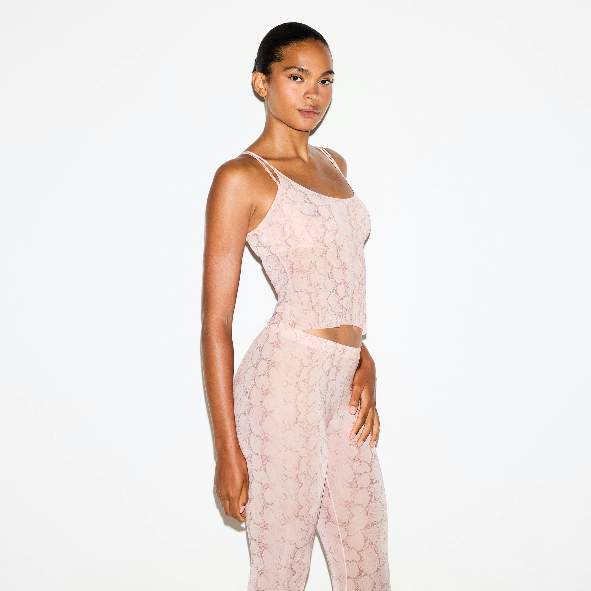 MILKY SHEER FOOTED LEGGING | ROSE PASTEL SNAKE PRINT ON A MODEL SIDE VIEW @ | FOCUS: 0.0, 1.0, 0.9