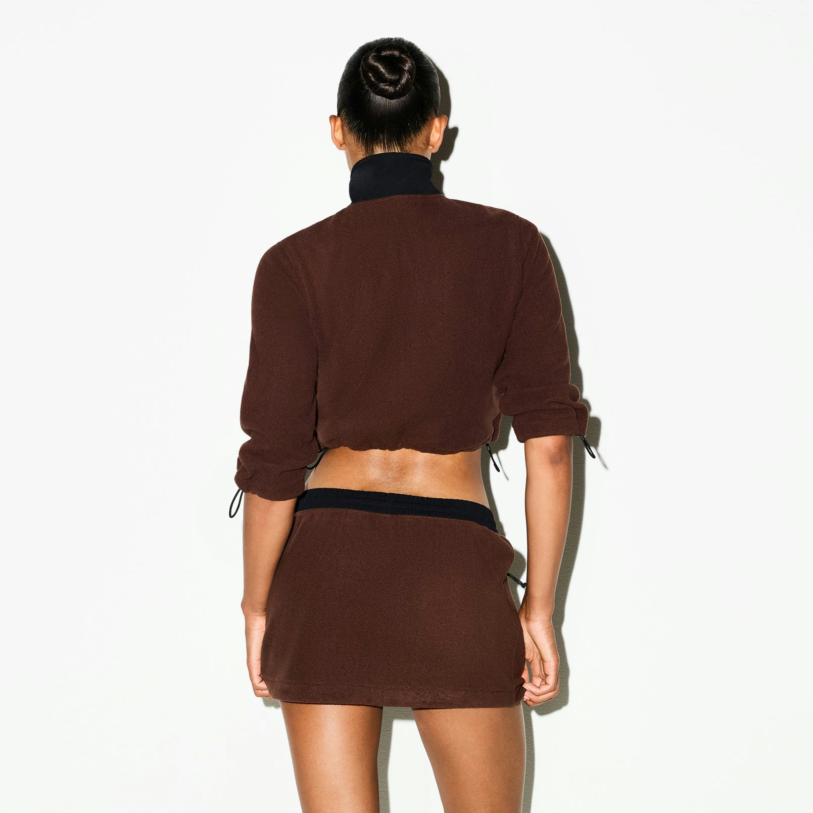 OUTDOOR FLEECE MINI SKIRT | COCOA ON A MODEL SIDE VIEW @ | FOCUS: 0.0, 1.0, 0.9