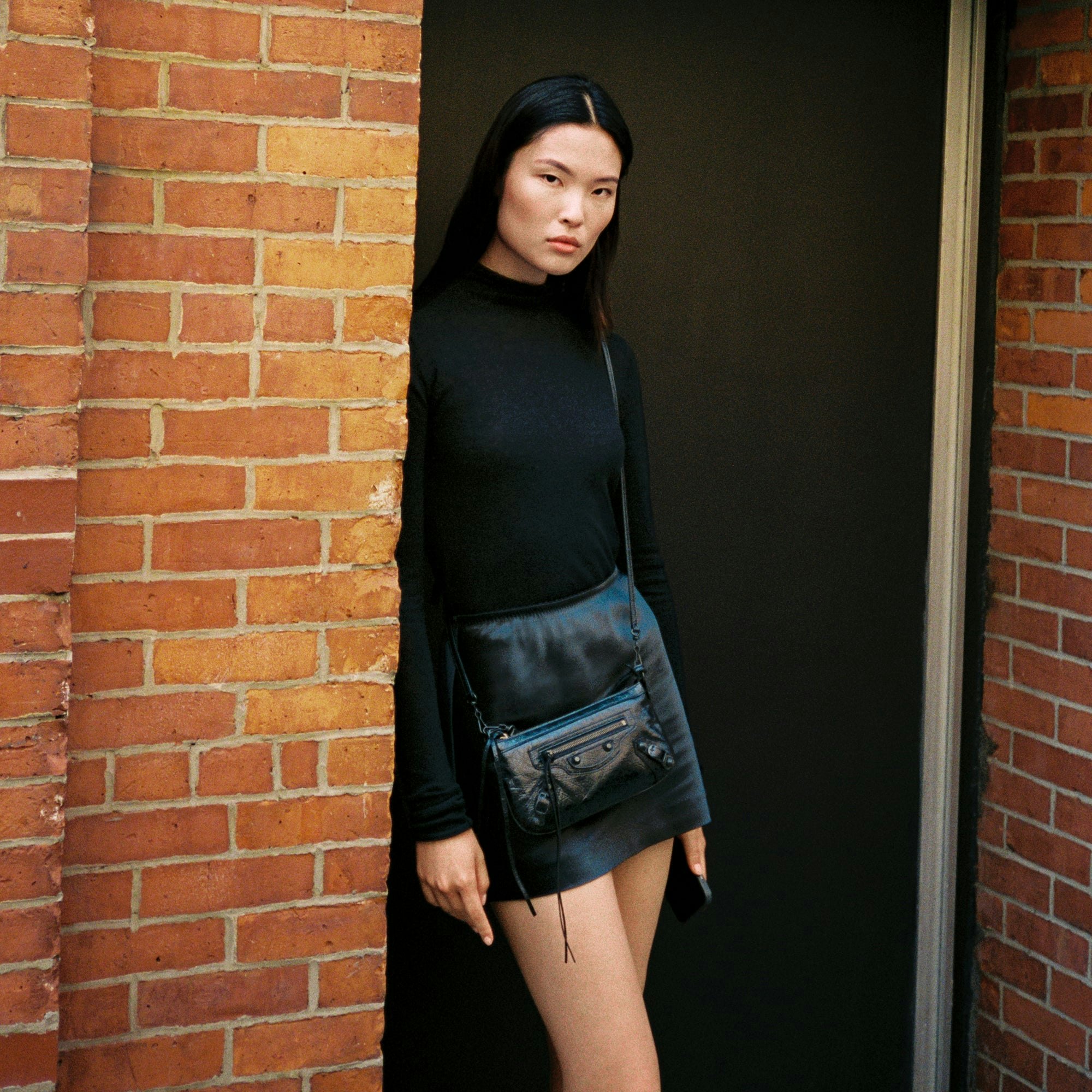 HEAVYWEIGHT SATIN MINI SKIRT | ONYX ON A MODEL SIDE VIEW @ | FOCUS: 0.0, 1.0, 0.9