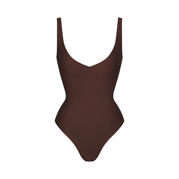 SKIMS BODY UNLINED PLUNGE THONG BODYSUIT | COCOA (SHAPEWEAR BODYSUITS, SHAPEWEAR) LAYS FLAT ON A WHITE BACKGROUND | FLT