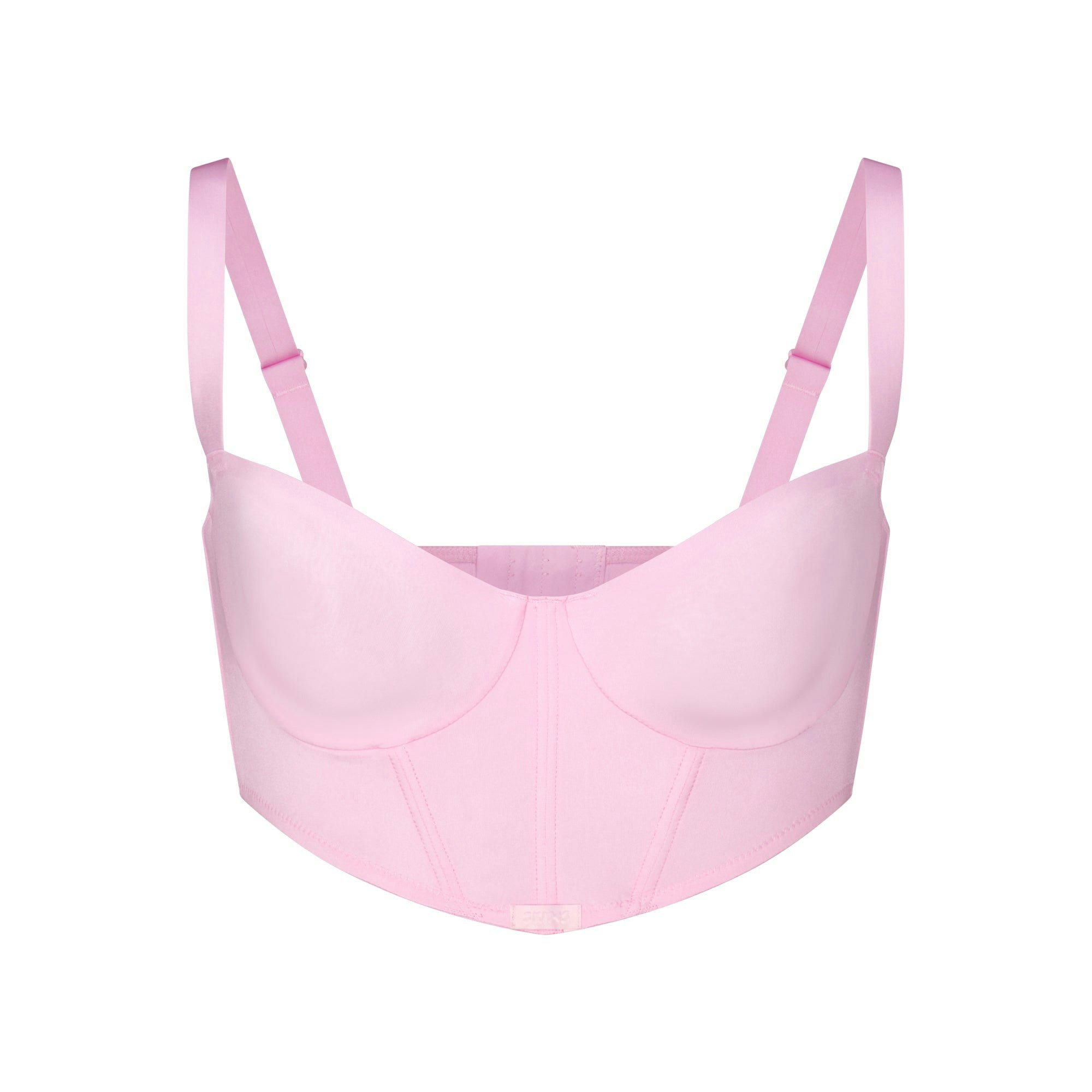 SKIMS LOGO SHINE BALCONETTE CORSET BRA | BABY PINK (BALCONETTE BRAS) LAYS FLAT ON A WHITE BACKGROUND | FLT