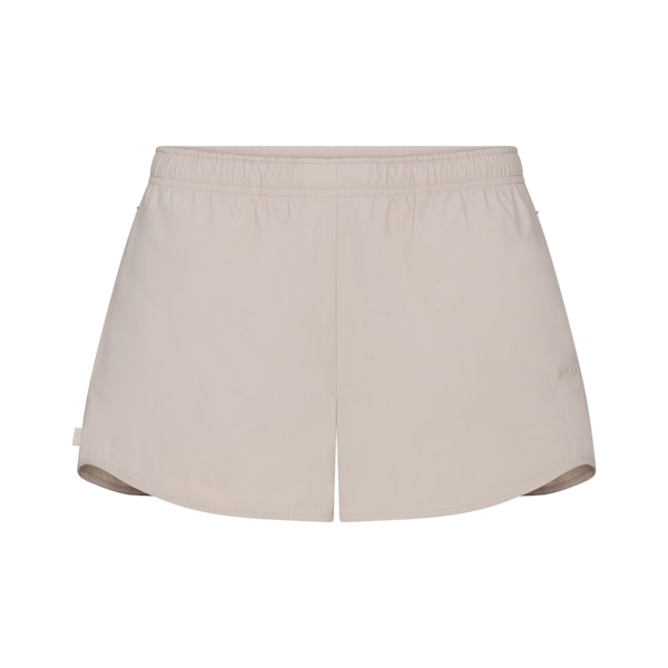 NikeSKIMS WOVEN NYLON 2.5" RUNNER SHORT | STONE FLAT ON A WHITE BACKGROUND | FLT