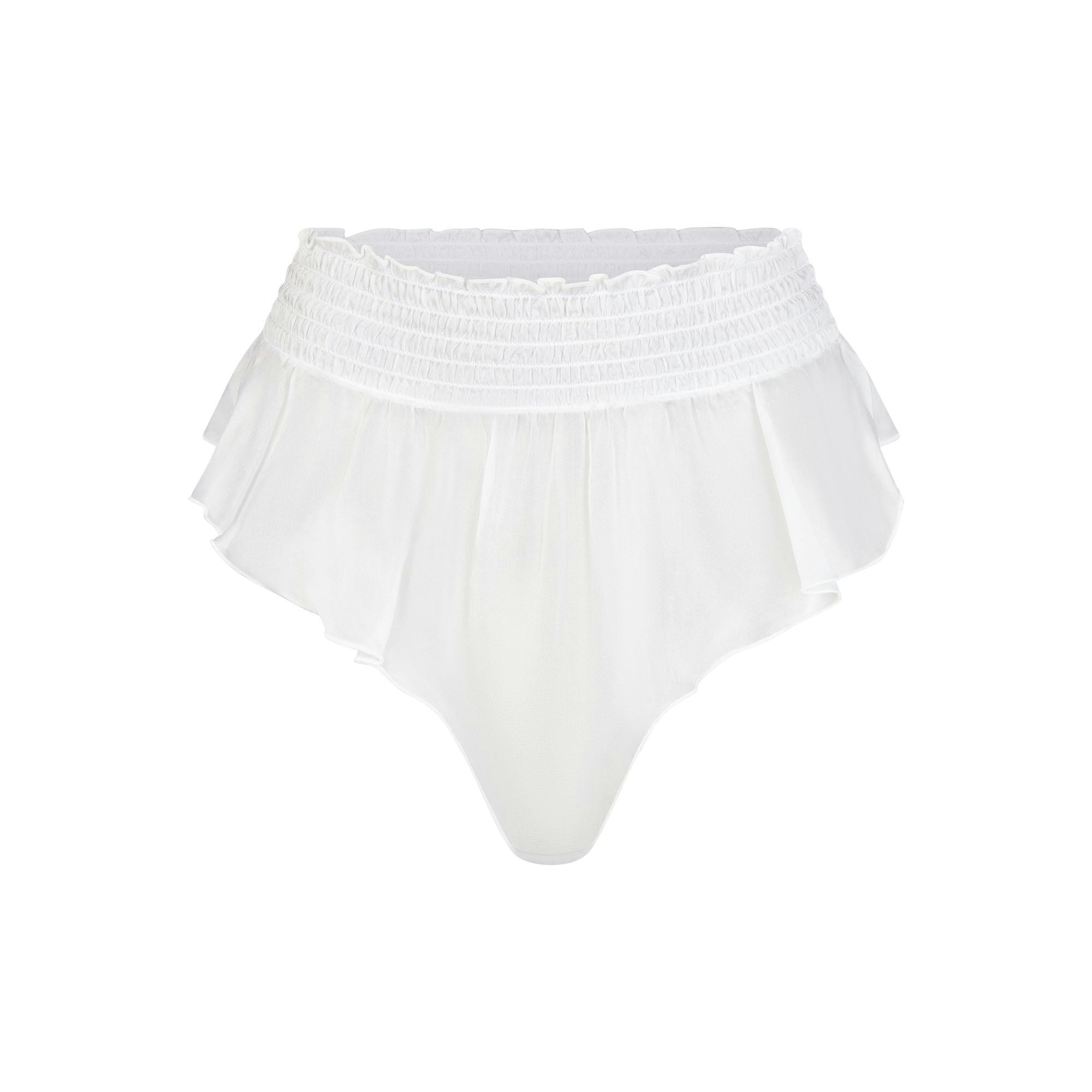 SKIMS ROMANCE SMOCKED FLUTTER THONG | SNOW (THONGS, PANTIES) LAYS FLAT ON A WHITE BACKGROUND
