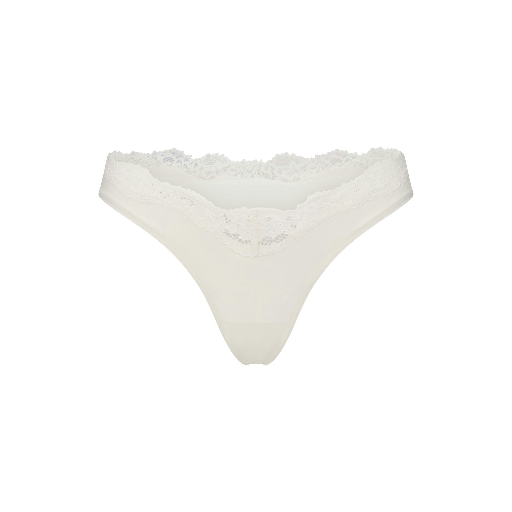 FITS EVERYBODY LACE DIPPED THONG 5-PACK | IVORY PEARL BOW MULTI LAYS FLAT ON A WHITE BACKGROUND