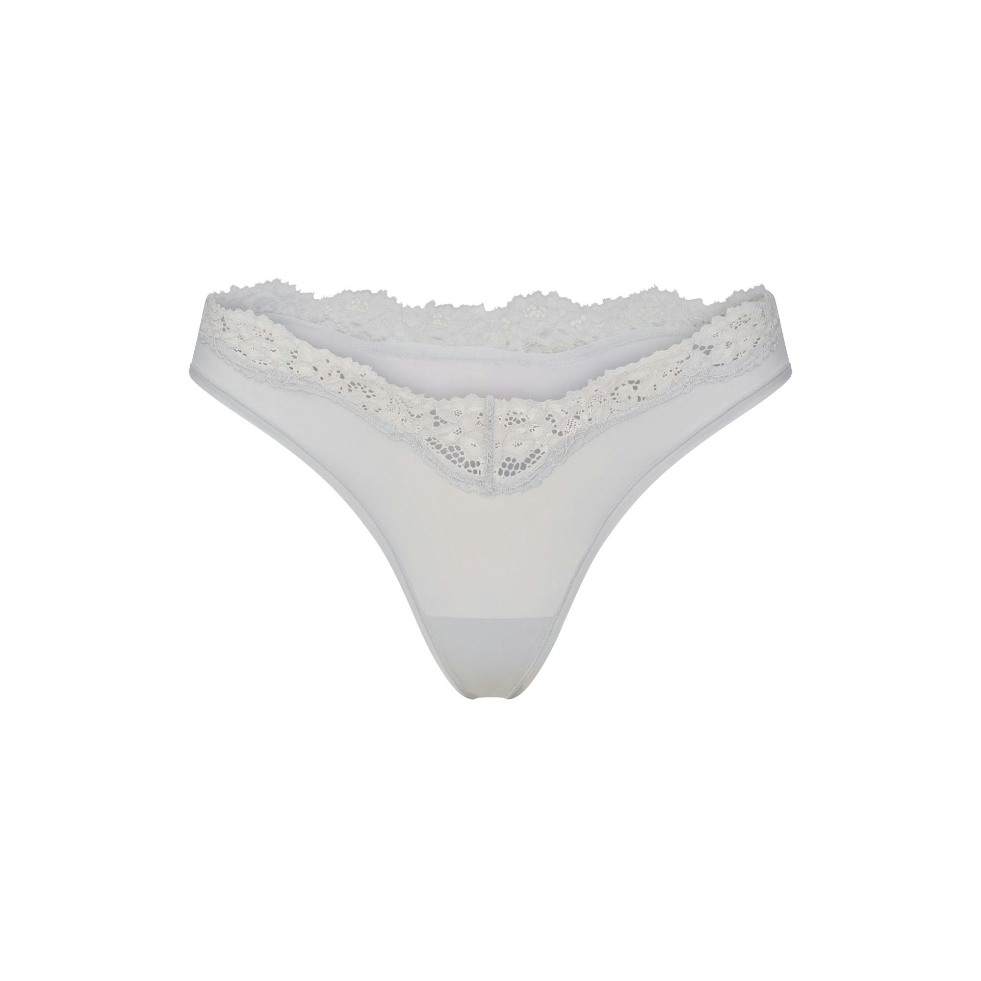 FITS EVERYBODY LACE DIPPED THONG 5-PACK | IVORY PEARL BOW MULTI LAYS FLAT ON A WHITE BACKGROUND