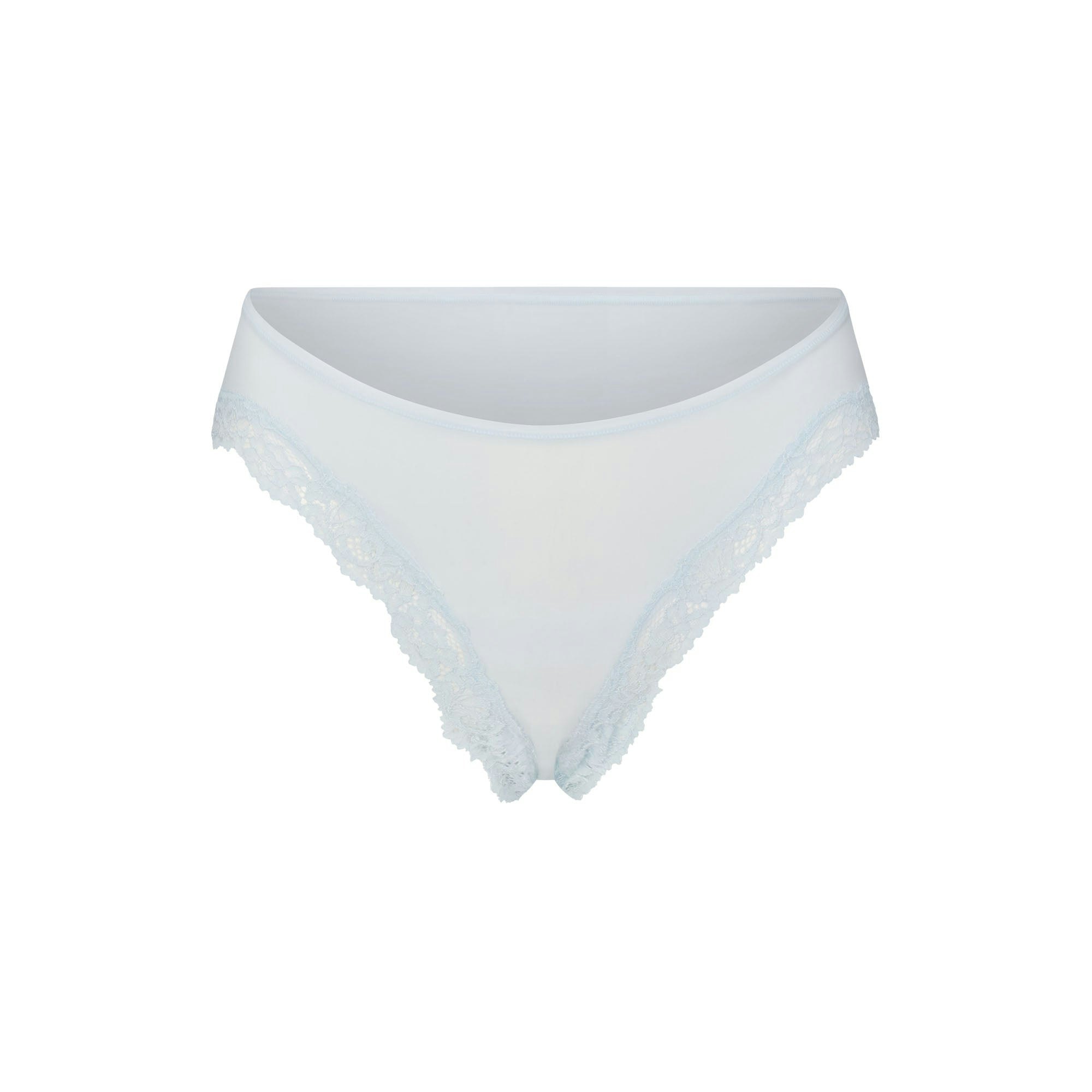 FITS EVERYBODY LACE CHEEKY TANGA 5-PACK | IVORY PEARL BOW MULTI LAYS FLAT ON A WHITE BACKGROUND