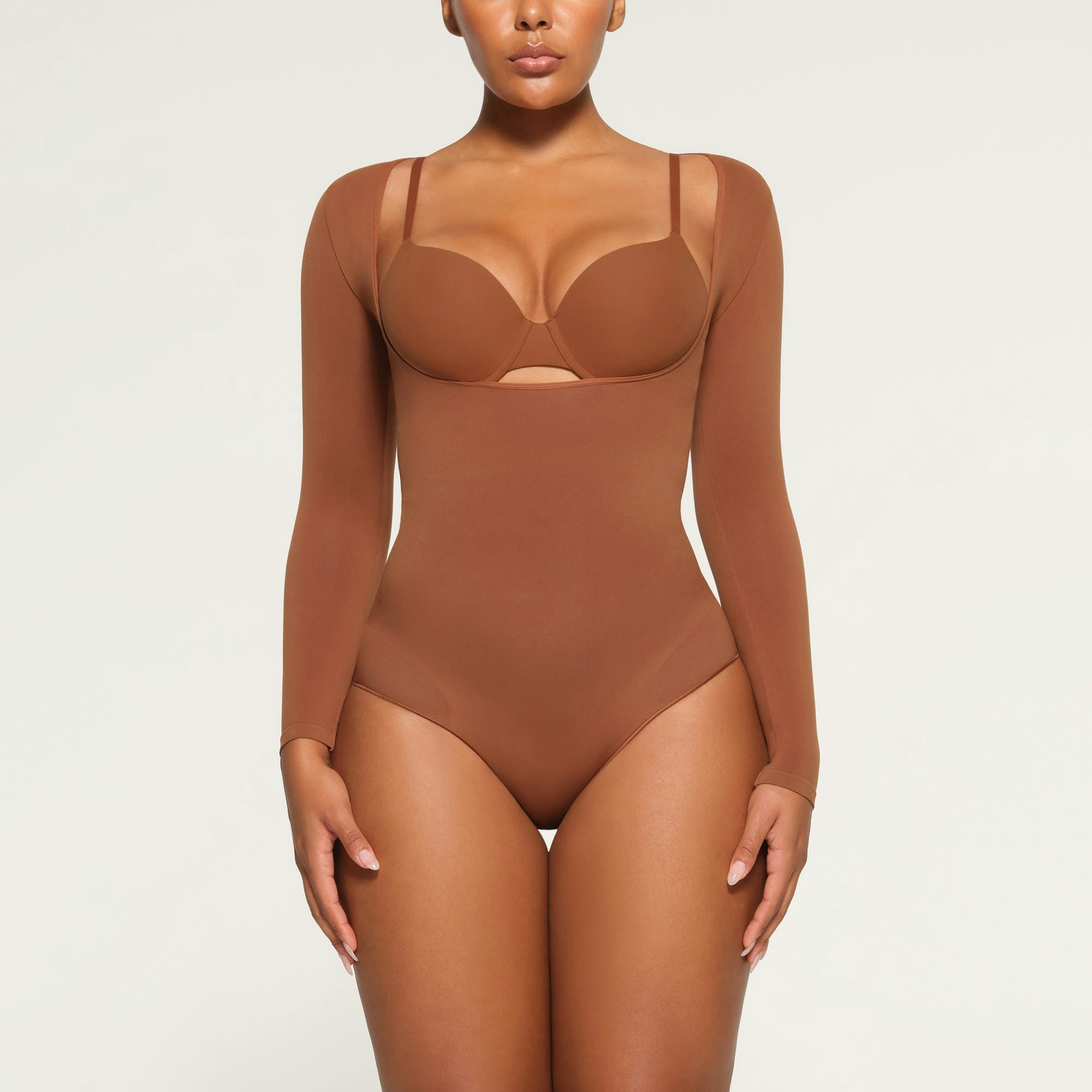 SEAMLESS SCULPT LONG SLEEVE OPEN BUST BRIEF BODYSUIT WORN BY A MODEL IN FRONT VIEW