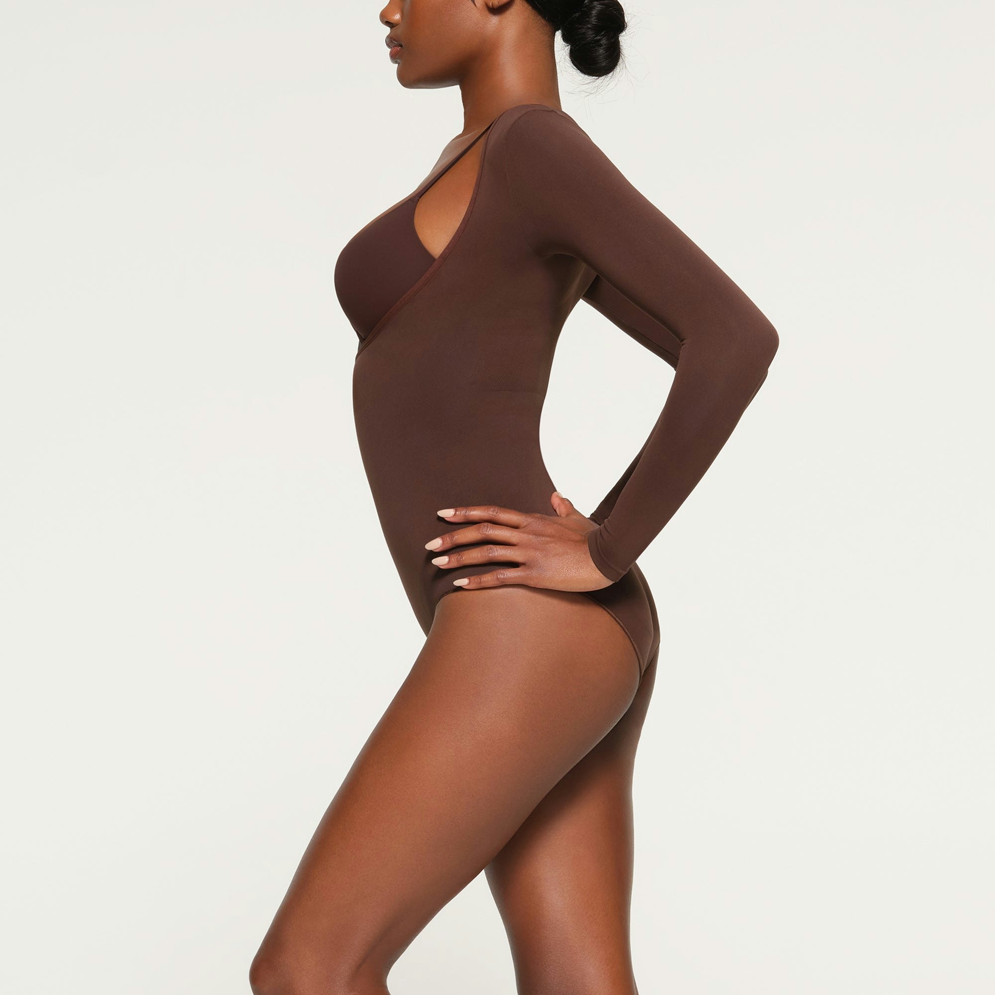 SEAMLESS SCULPT LONG SLEEVE OPEN BUST BRIEF BODYSUIT WORN BY A MODEL IN SIDE VIEW