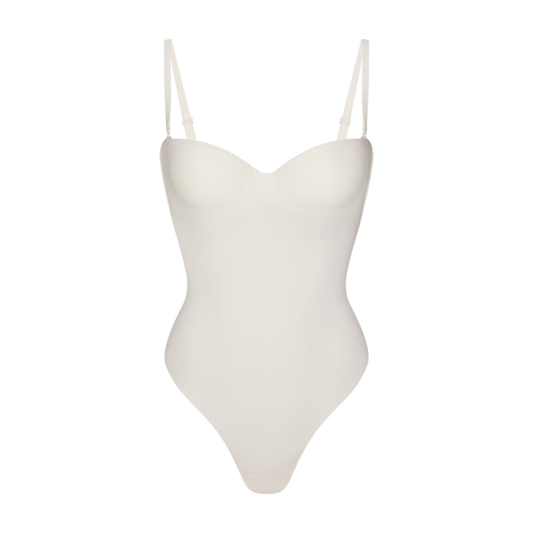 SKIMS BODY UNDERWIRE THONG BODYSUIT | IVORY FLAT ON A WHITE BACKGROUND | FLT