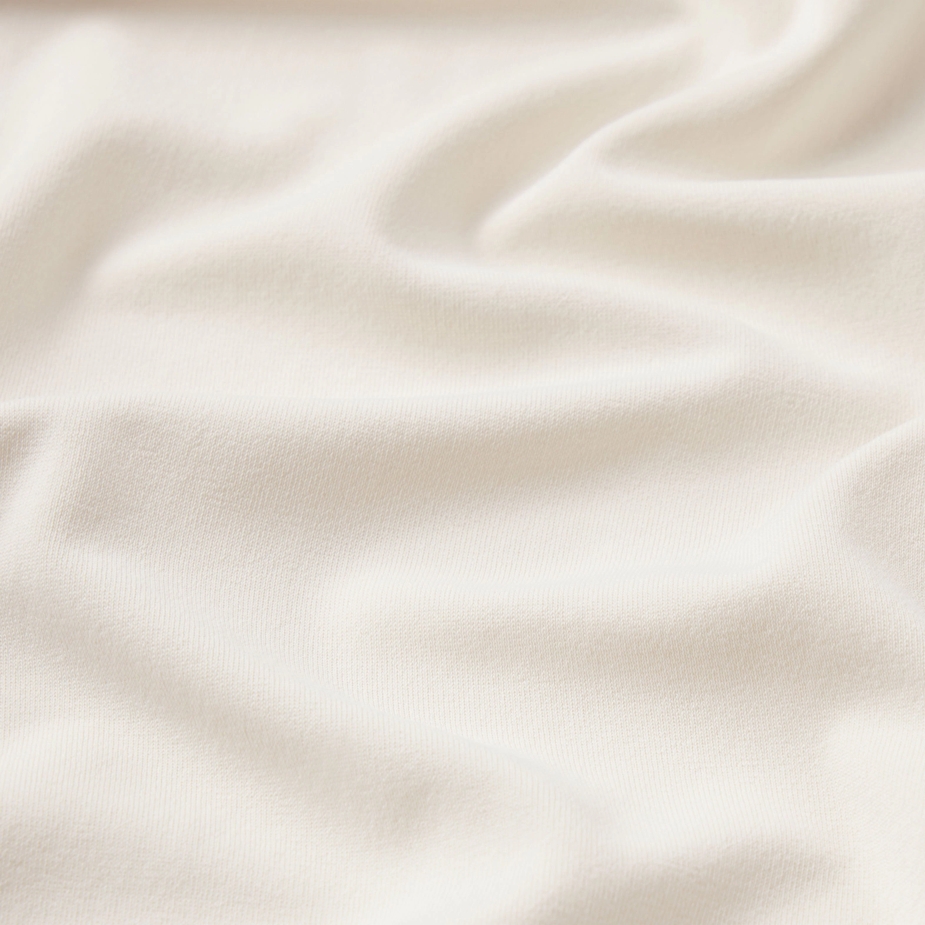 NikeSKIMS STRETCH KNIT CROPPED T-SHIRT | IVORY & LAYS FLAT ON A WHITE BACKGROUND | FLT
