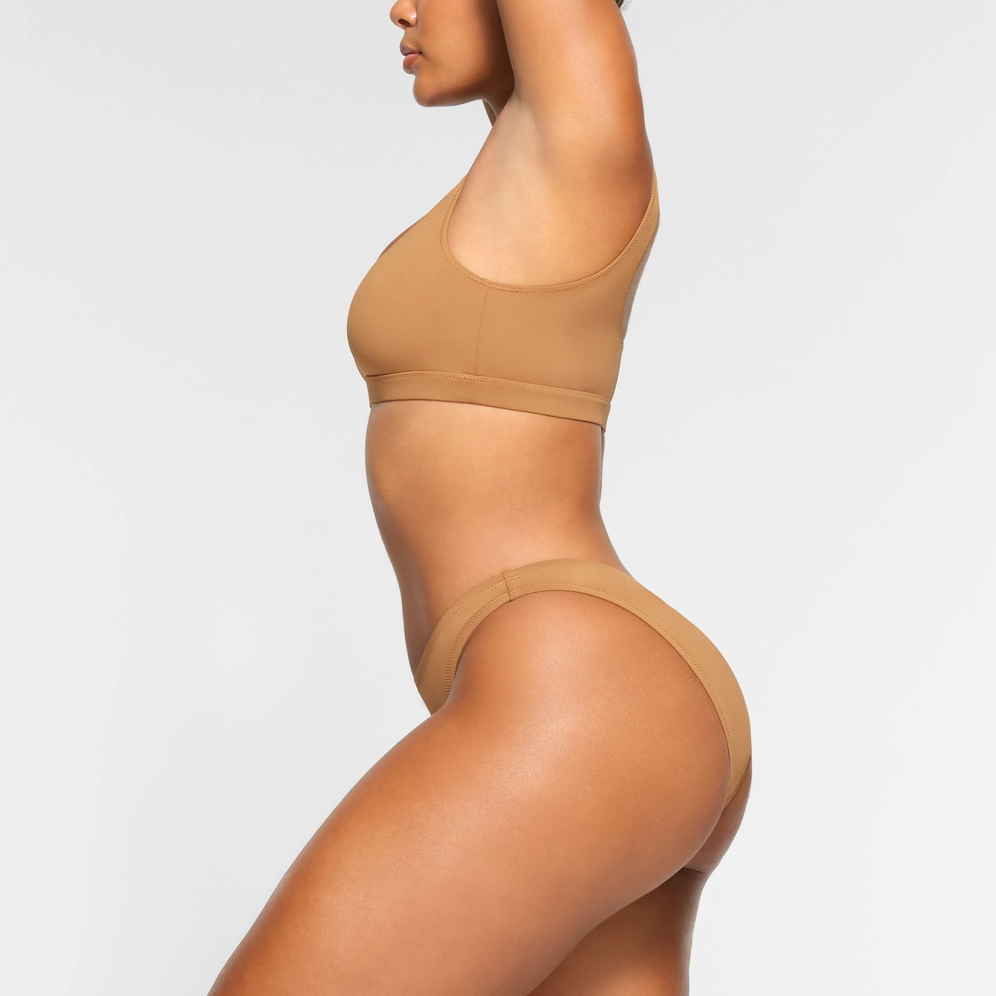 SWIM MID COVERAGE BOTTOMS WORN BY A MODEL IN SIDE VIEW