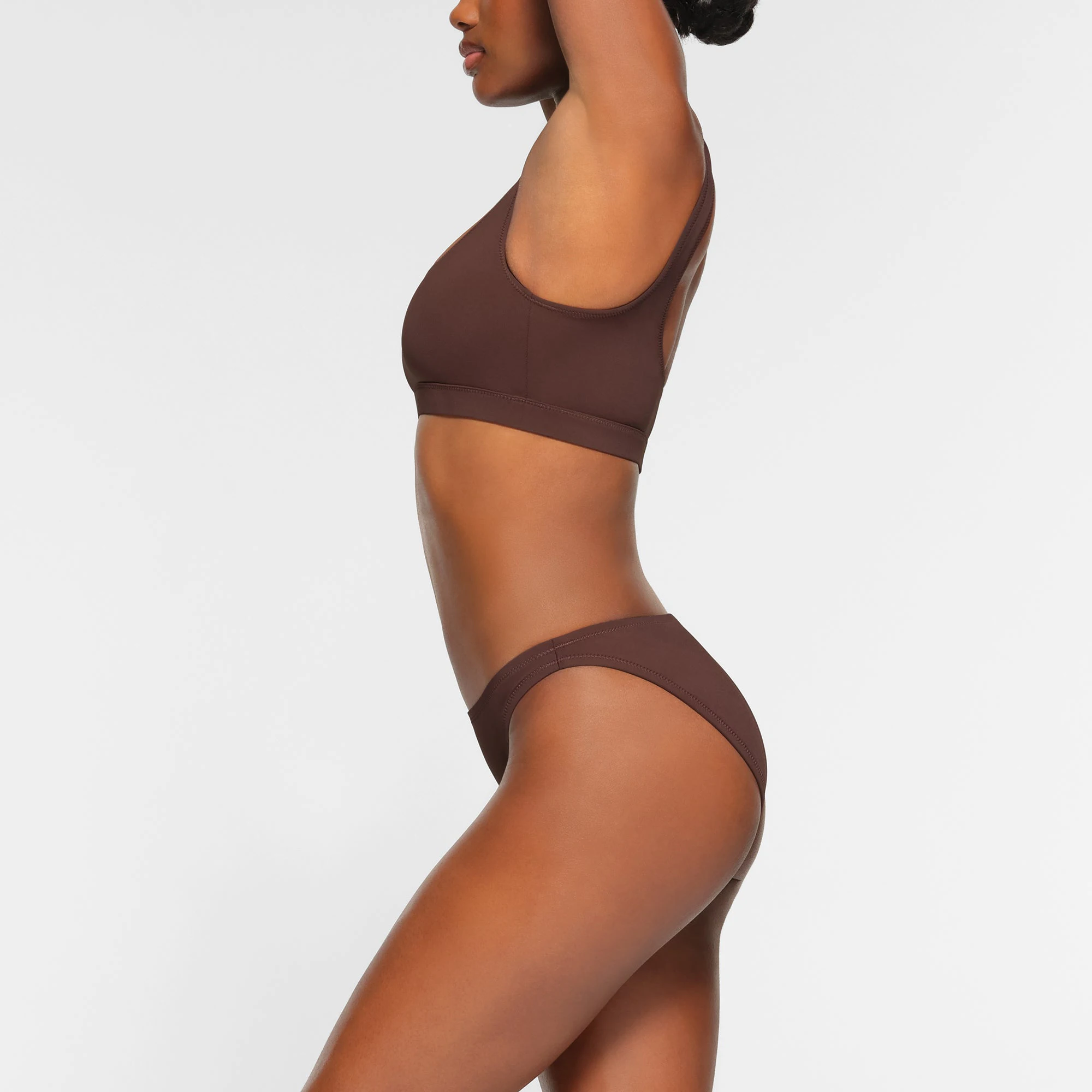 SWIM MID COVERAGE BOTTOMS WORN BY A MODEL IN SIDE VIEW