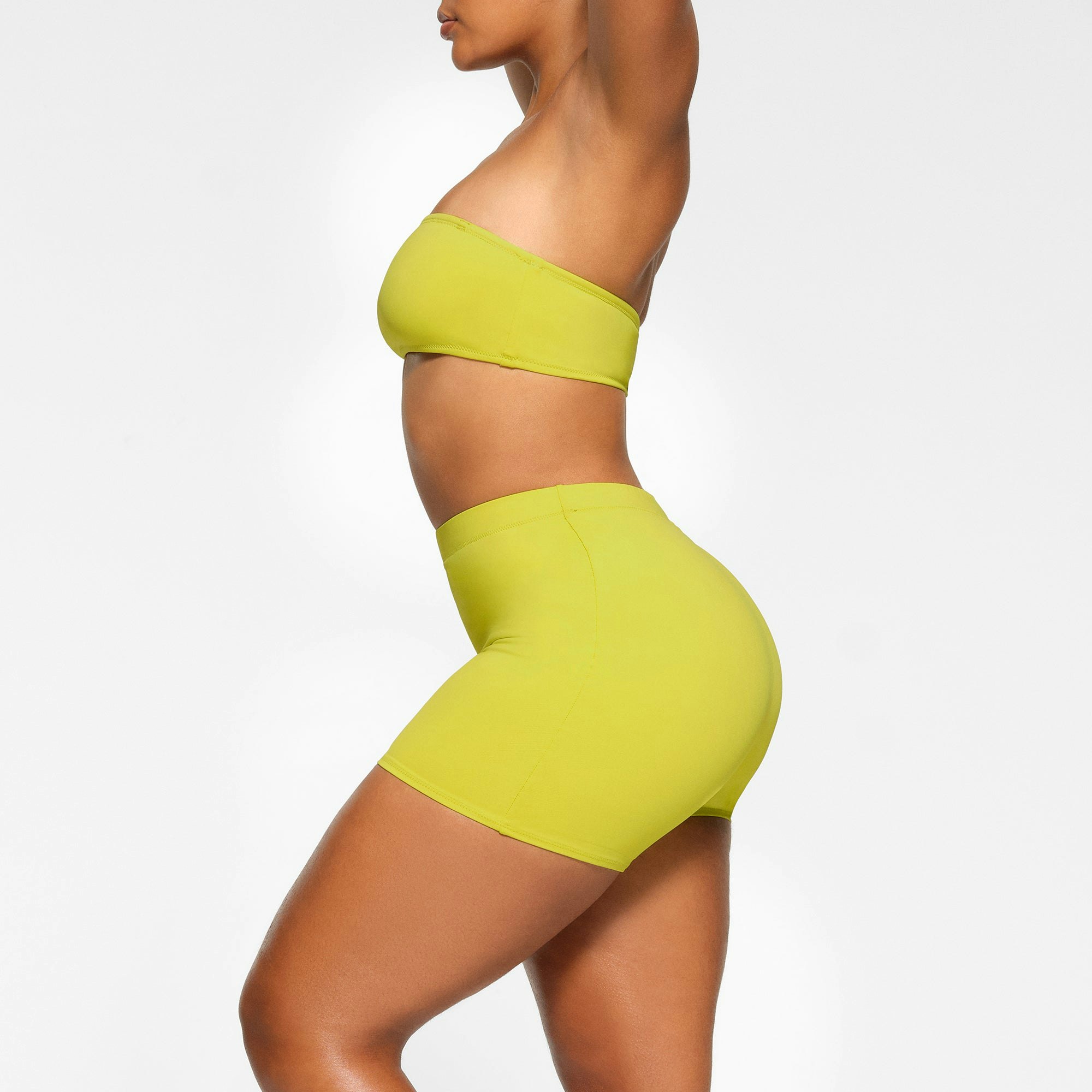 SWIM MID WAIST SHORT WORN BY A MODEL IN SIDE VIEW