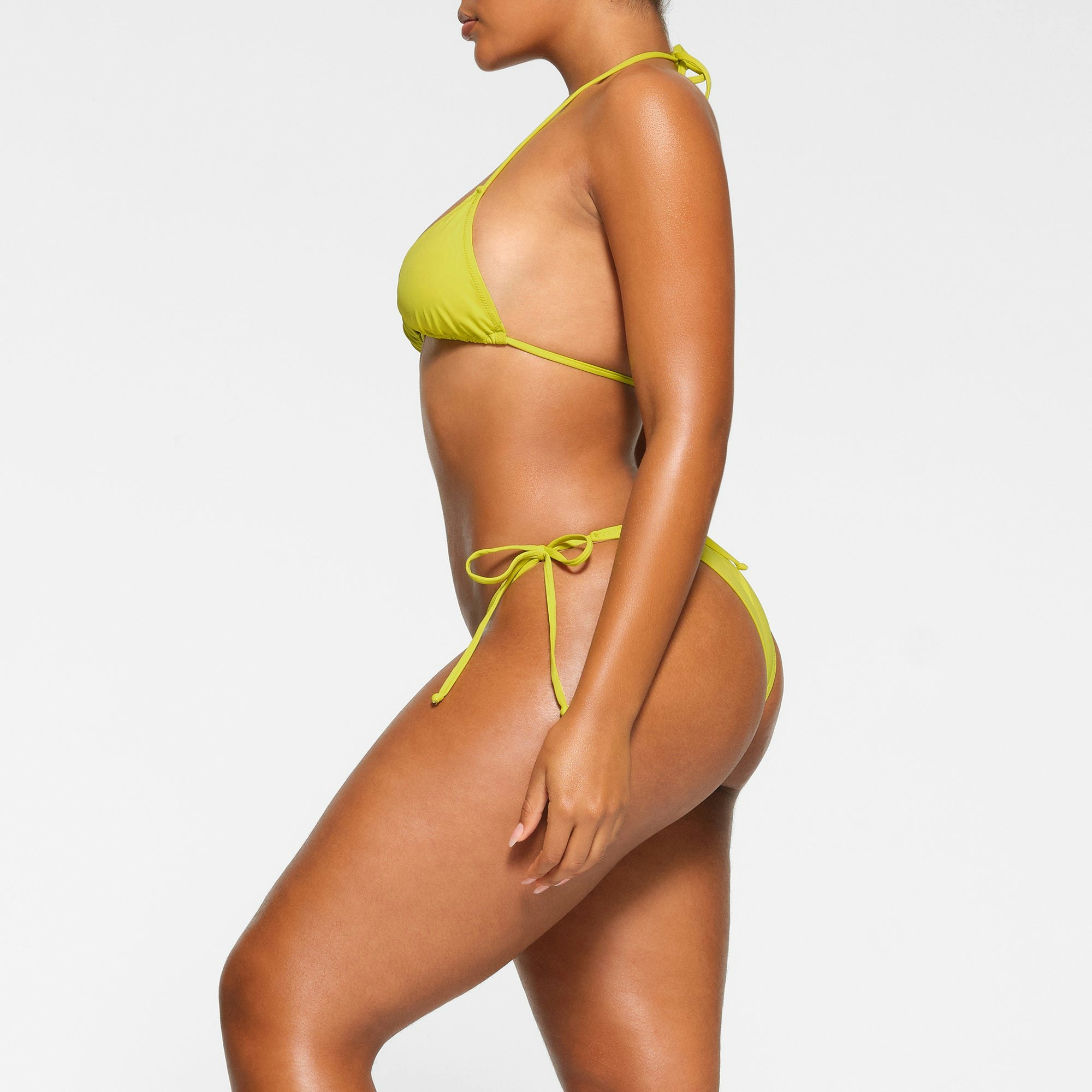 SWIM TRIANGLE TOP WORN BY A MODEL IN SIDE VIEW