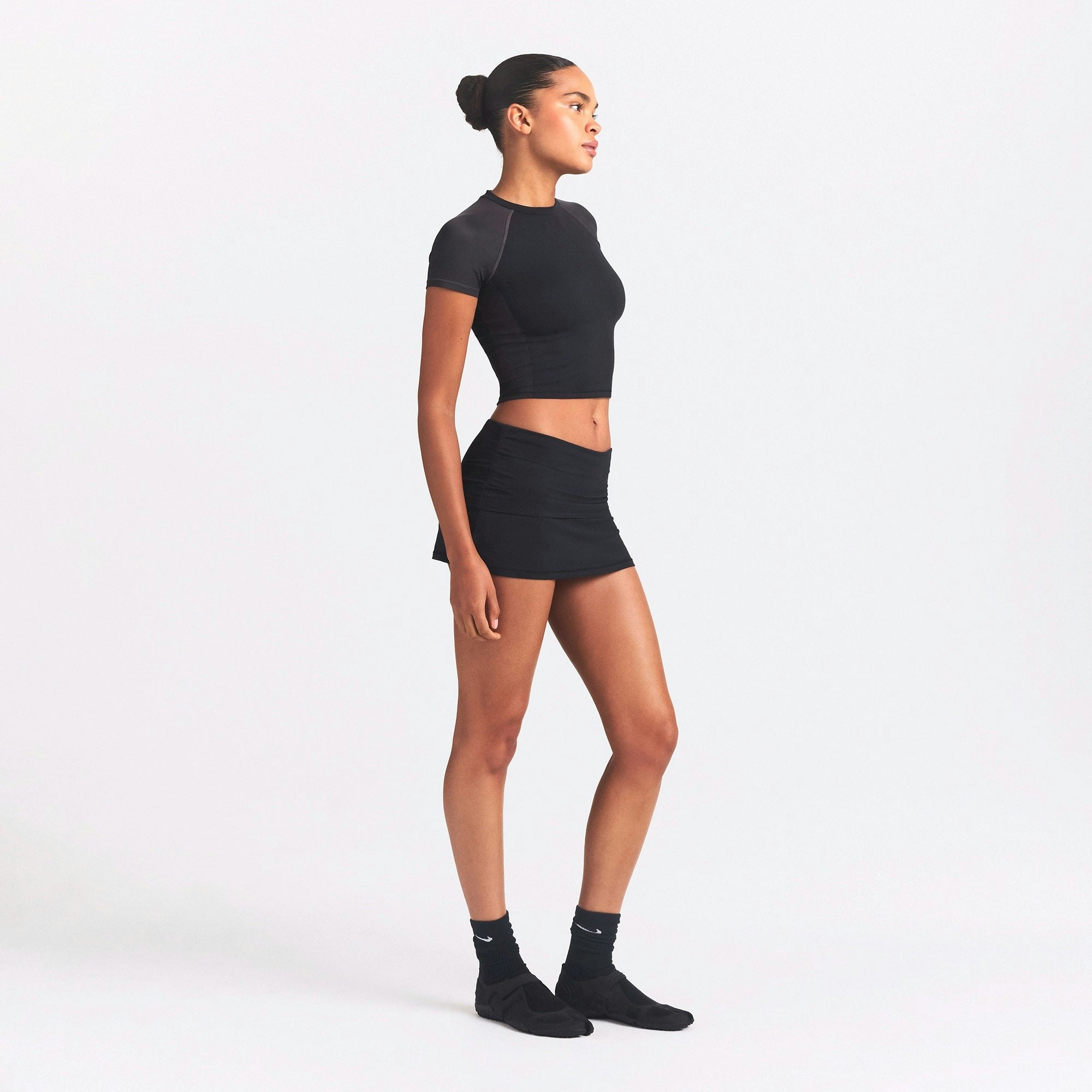 NikeSKIMS AIRY FOLDOVER SKORT | OBSIDIAN ON A MODEL SIDE VIEW @ | FOCUS: 0.0, 1.0, 0.9