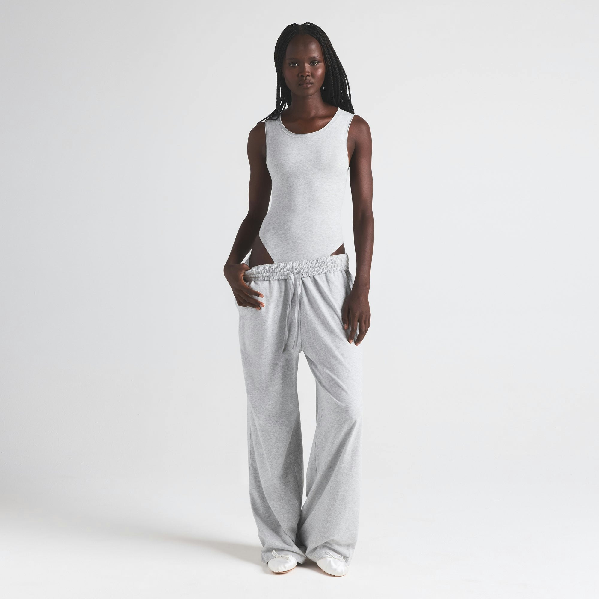 COTTON JERSEY TANK BODYSUIT | LIGHT HEATHER GREY ON A MODEL FRONT VIEW | FOCUS: 0.0, 1.0, 0.9