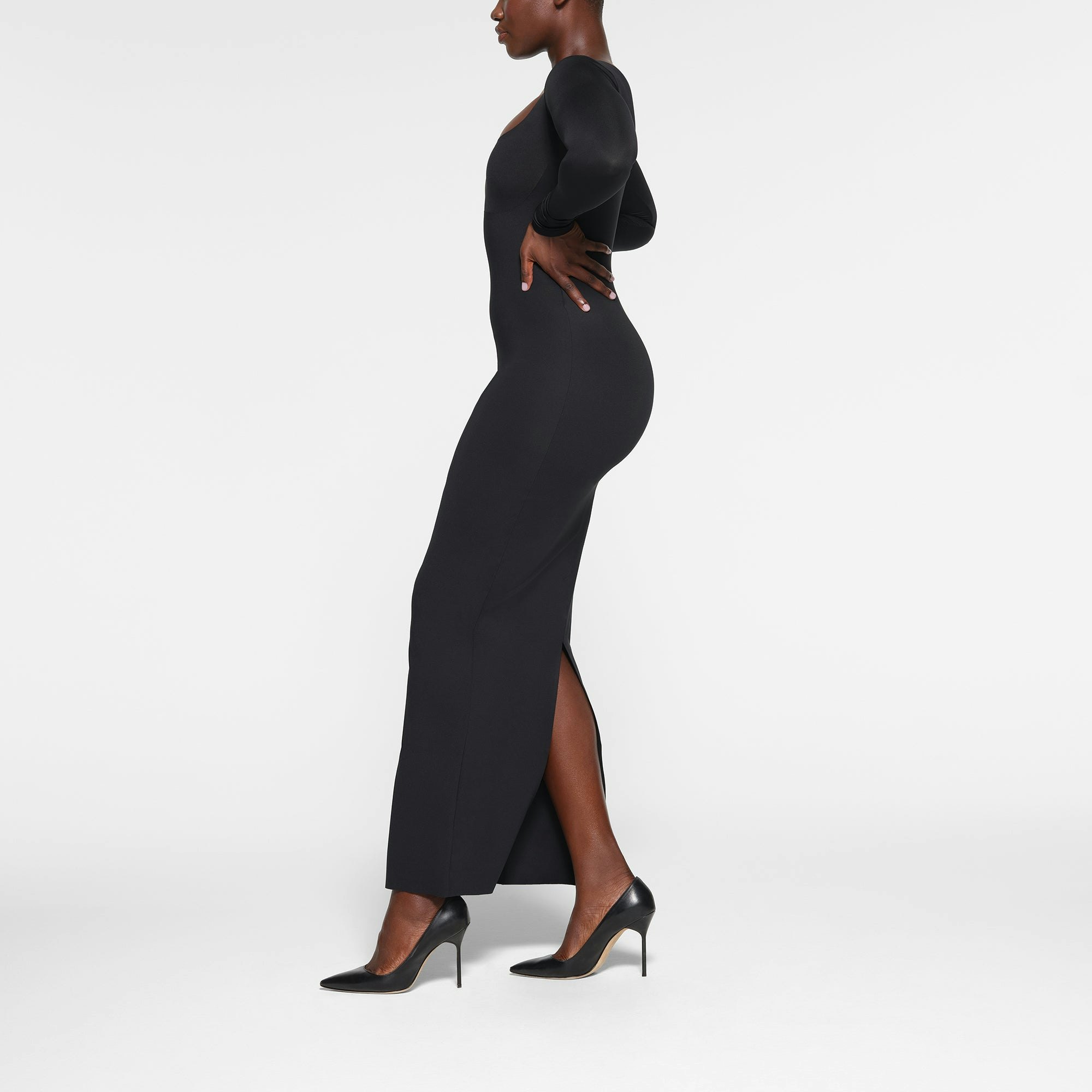 SKIMS BODY LONG SLEEVE LONG DRESS WORN BY A MODEL IN SIDE VIEW