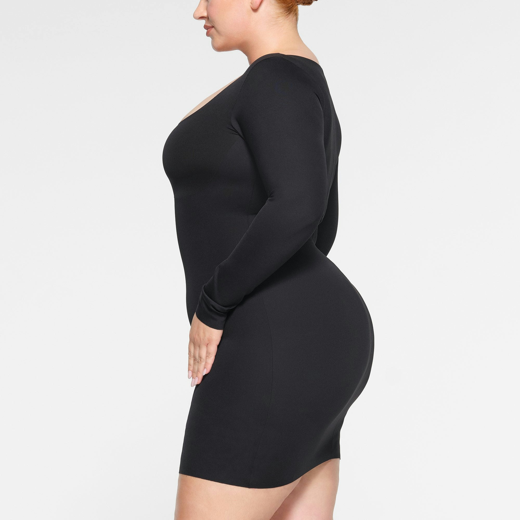 SKIMS BODY LONG SLEEVE MINI DRESS WORN BY A MODEL IN SIDE VIEW