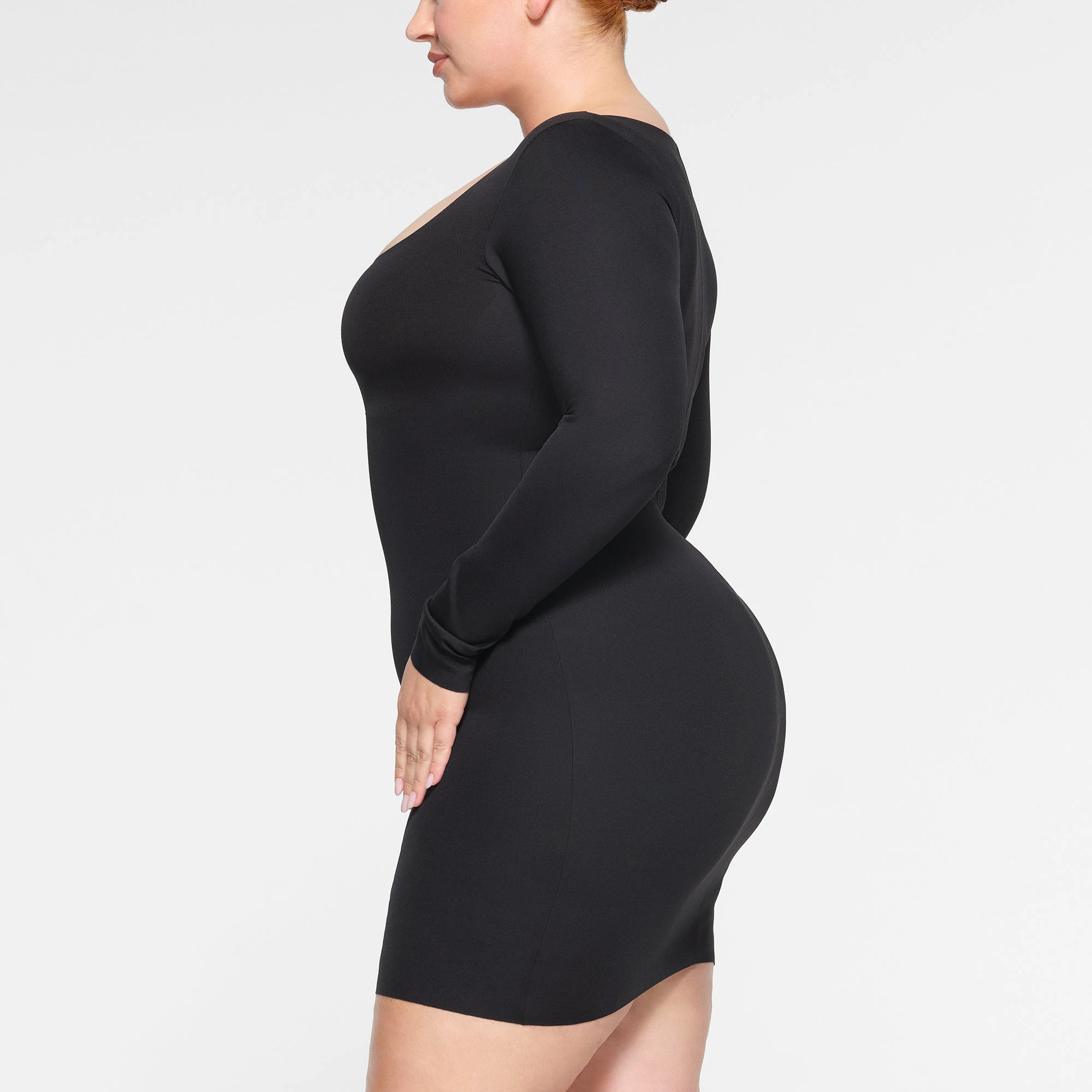 SKIMS BODY LONG SLEEVE MINI DRESS WORN BY A MODEL IN SIDE VIEW