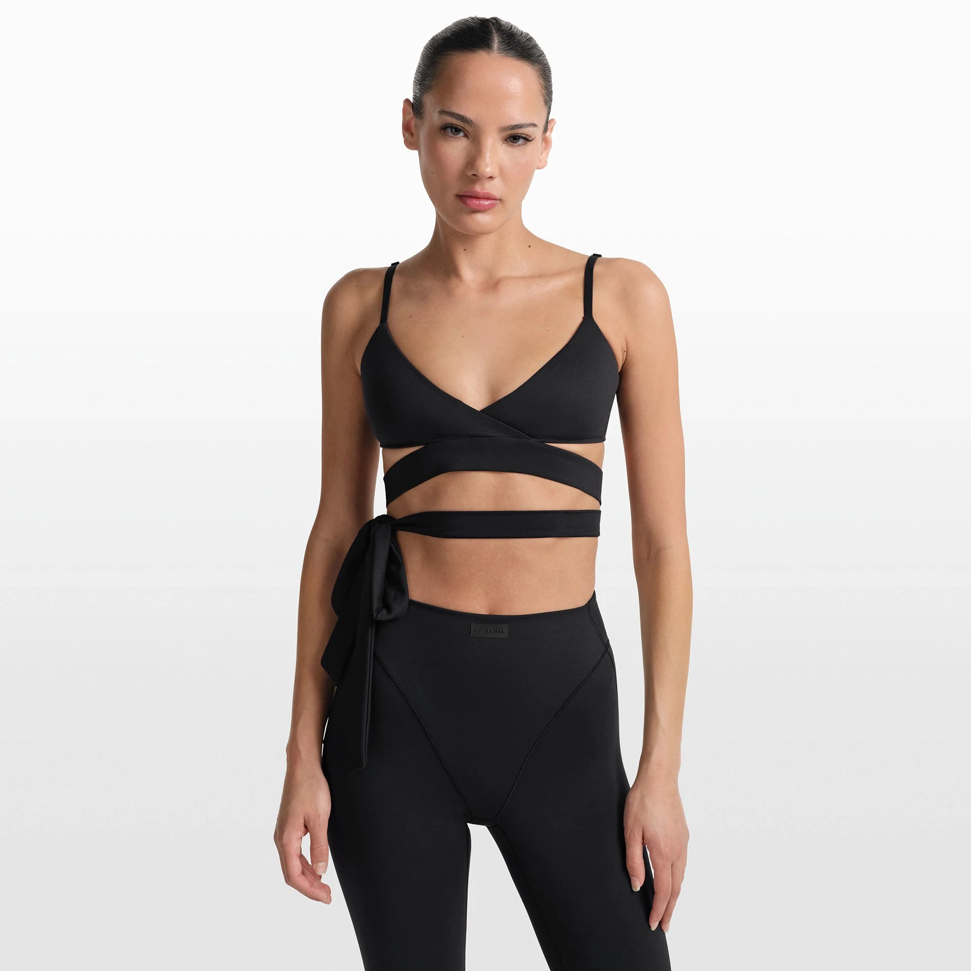 NikeSKIMS MATTE WRAP FRONT BRA | OBSIDIAN ON A MODEL FRONT VIEW @ | FOCUS: 0.0, 1.0, 0.9