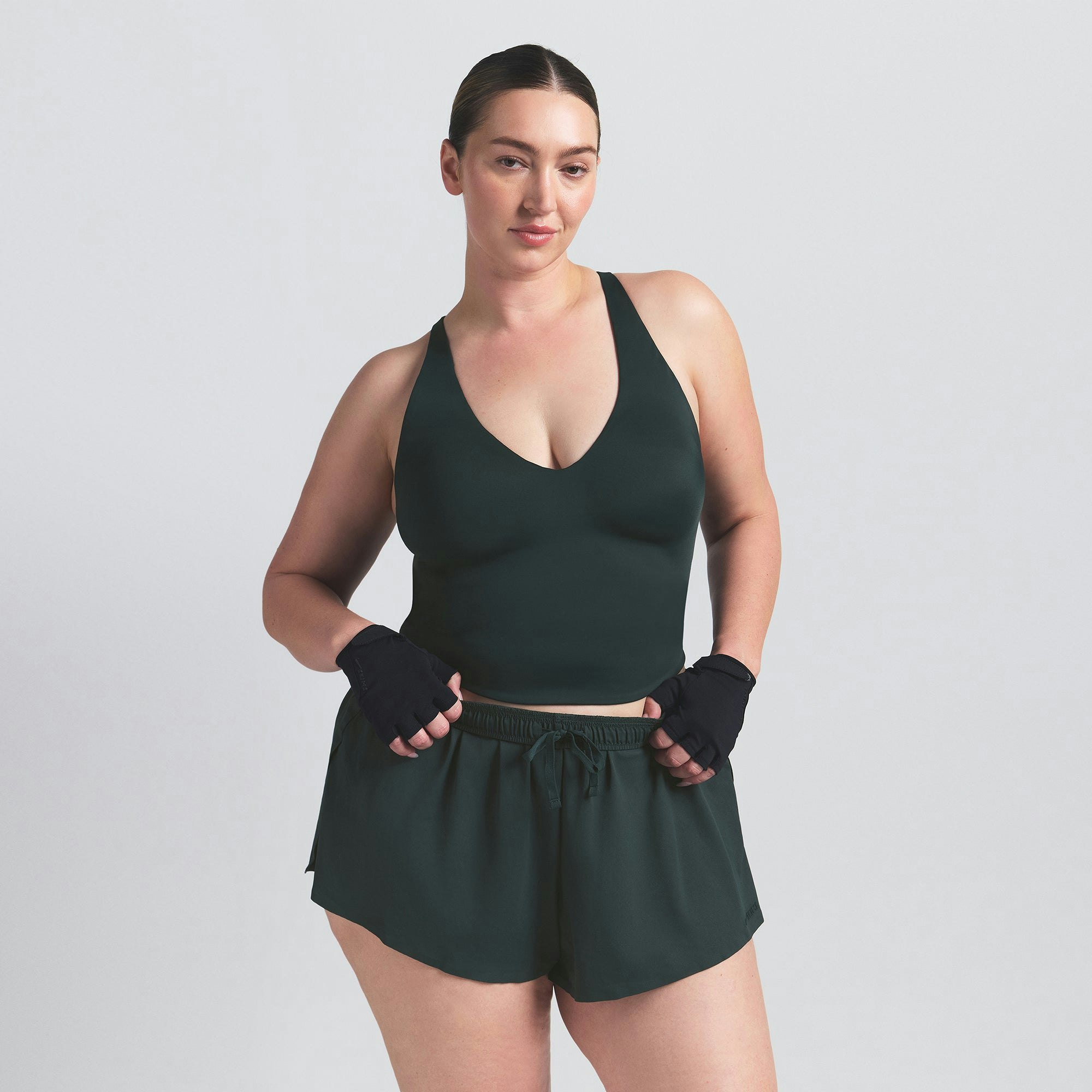 NikeSKIMS SHINE V-NECK TANK | DARK TEAL ON A MODEL SIDE VIEW @ | FOCUS: 0.0, 1.0, 0.9