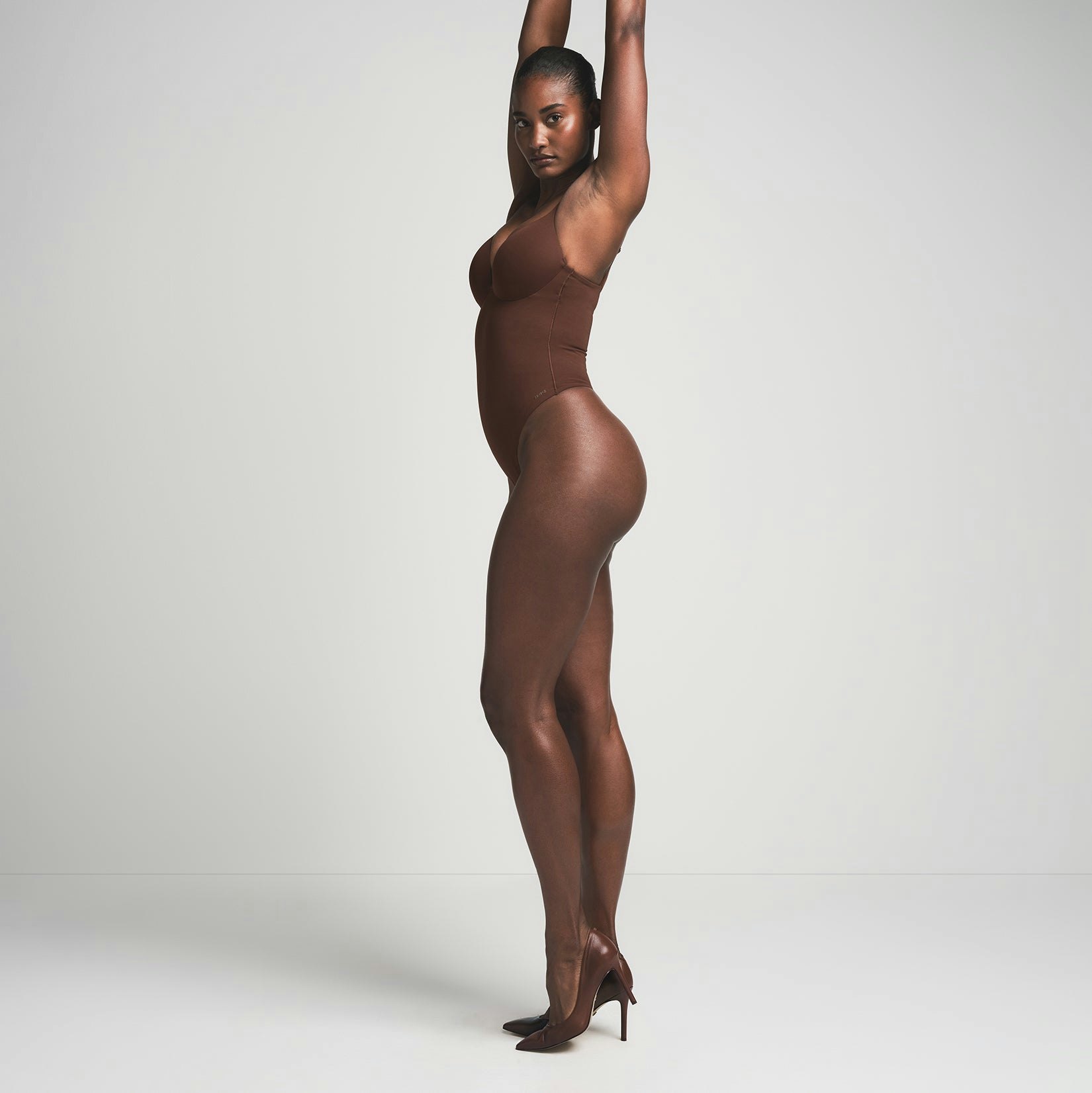 SKIMS ULTIMATE BODY PUSH-UP THONG BODYSUIT | COCOA  ON A MODEL SIDE VIEW | FOCUS: 0.0, 1.0, 0.9