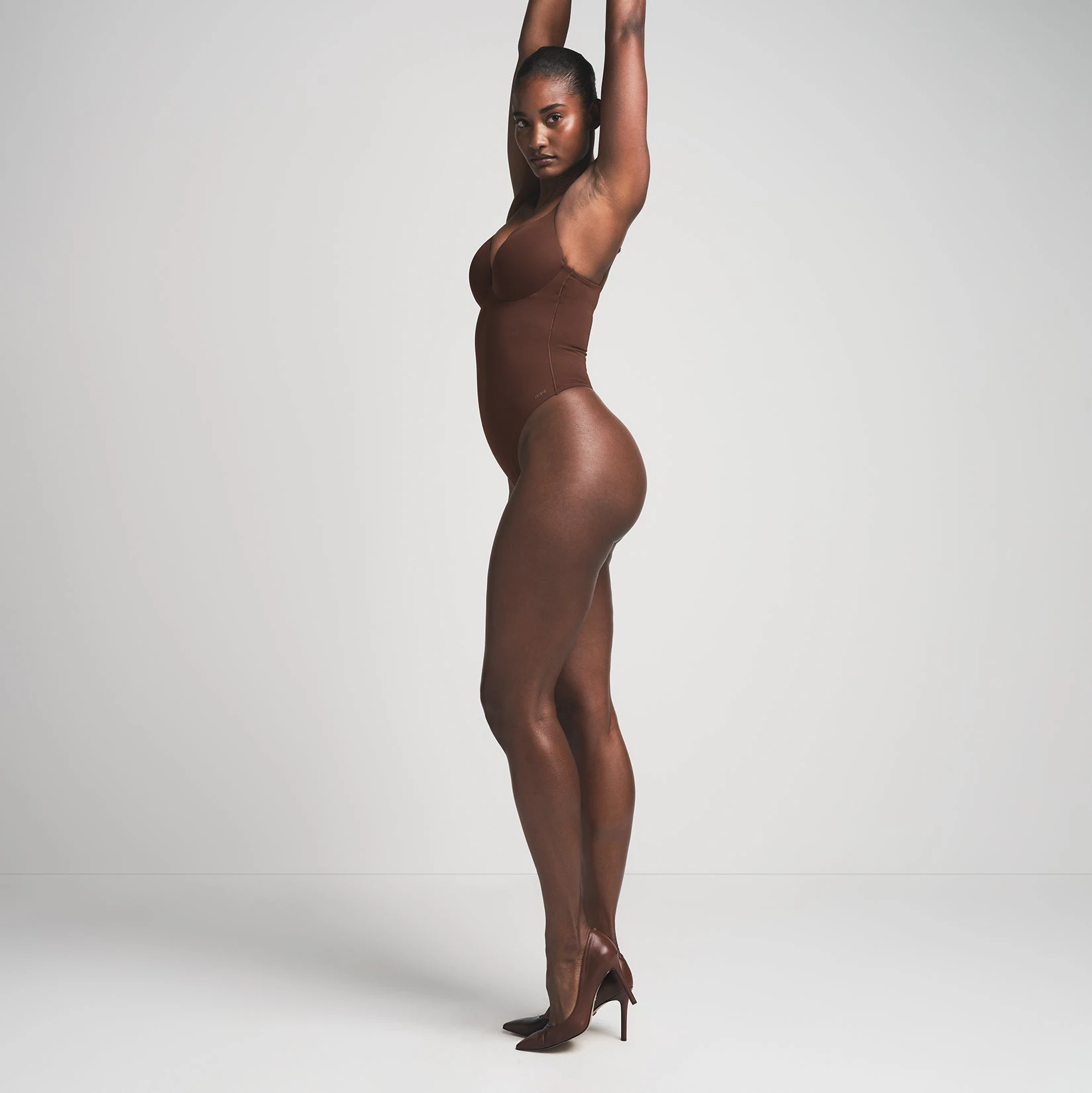 SKIMS ULTIMATE BODY PUSH-UP THONG BODYSUIT | COCOA ON A MODEL SIDE VIEW